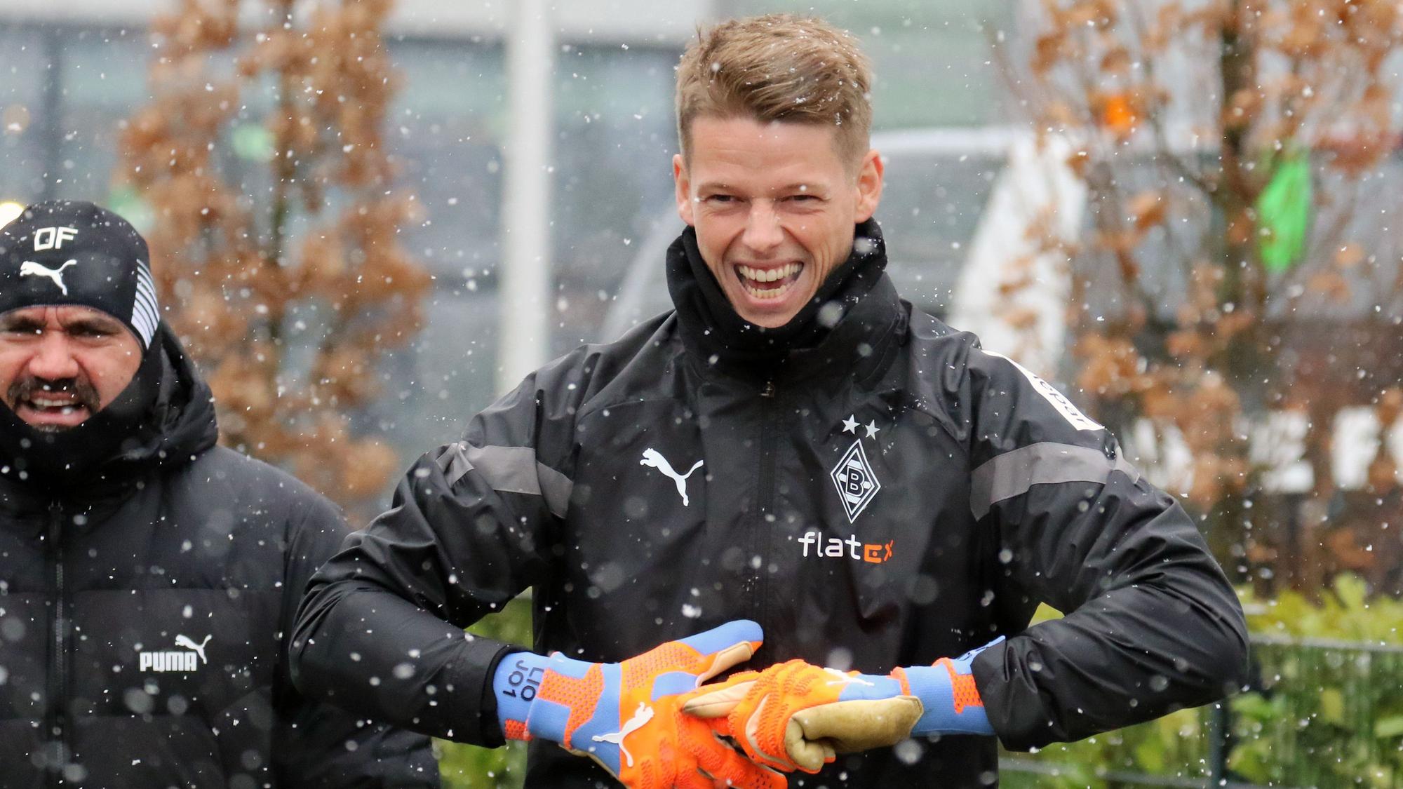 Der neue Gladbach-Keeper Jonas Omlin hat am Freitag (20. Januar 2023) bei Schneefall mit den Teamkollegen im Borussia-Park trainiert. Omlin lacht, im Hintergrund ist Daniel Farke zu sehen.