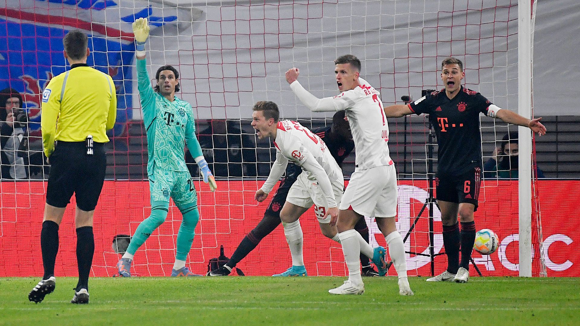 Yann Sommer steht beim Spiel gegen RB Leipzig am 21. Januar 2023 erstmals im Tor des FC Bayern München. Beim Bayern-Gegentor streckt der Schweizer in seinem grünen Torwarttrikot den rechten Arm in die Luft und zeigt den von Manuel Neuer berühmt gemachten Reklamierarm. Die Spieler von RB Leipzig bejubeln ihren Treffer.