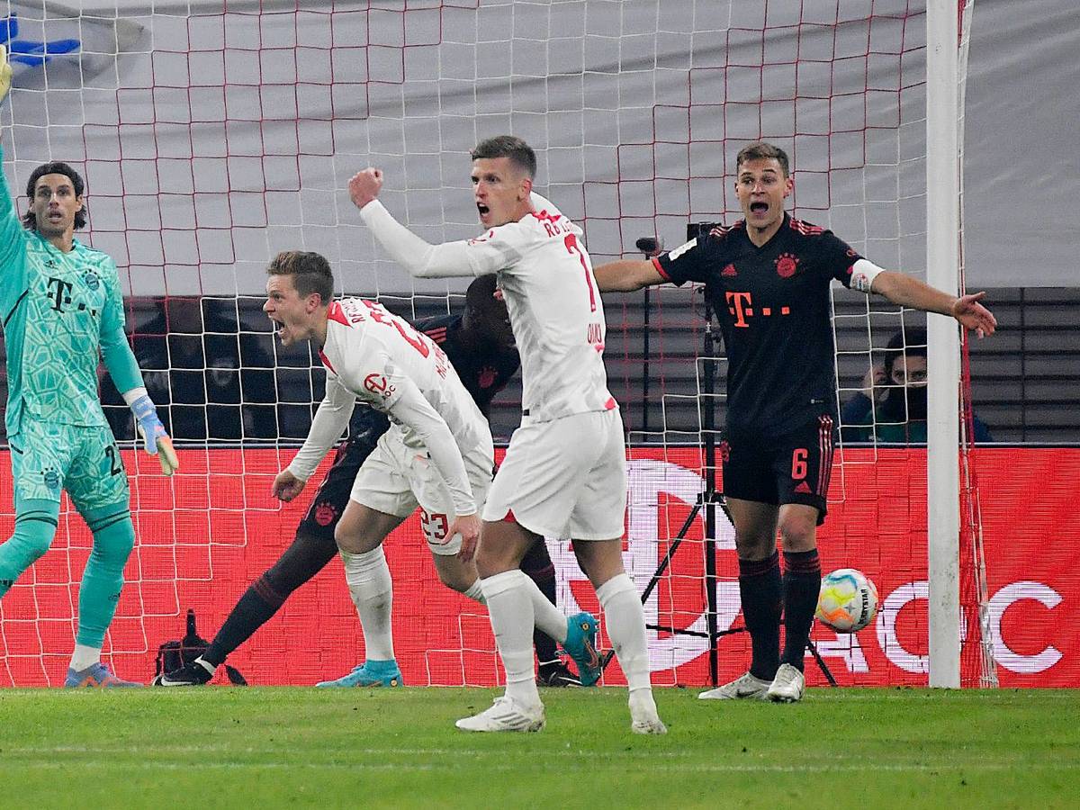 Yann Sommer steht beim Spiel gegen RB Leipzig am 21. Januar 2023 erstmals im Tor des FC Bayern München. Beim Bayern-Gegentor streckt der Schweizer in seinem grünen Torwarttrikot den rechten Arm in die Luft und zeigt den von Manuel Neuer berühmt gemachten Reklamierarm. Die Spieler von RB Leipzig bejubeln ihren Treffer.