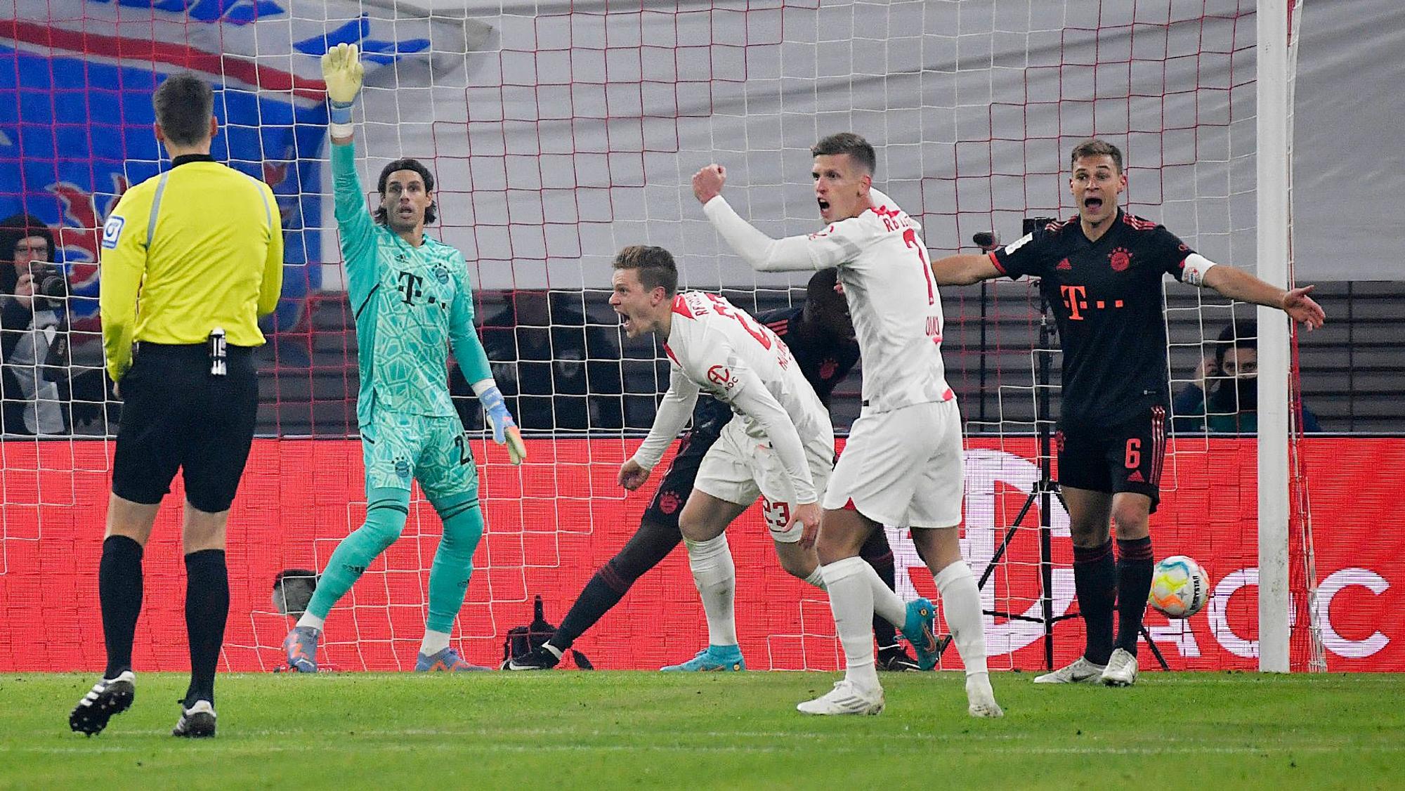 Yann Sommer steht beim Spiel gegen RB Leipzig am 21. Januar 2023 erstmals im Tor des FC Bayern München. Beim Bayern-Gegentor streckt der Schweizer in seinem grünen Torwarttrikot den rechten Arm in die Luft und zeigt den von Manuel Neuer berühmt gemachten Reklamierarm. Die Spieler von RB Leipzig bejubeln ihren Treffer.