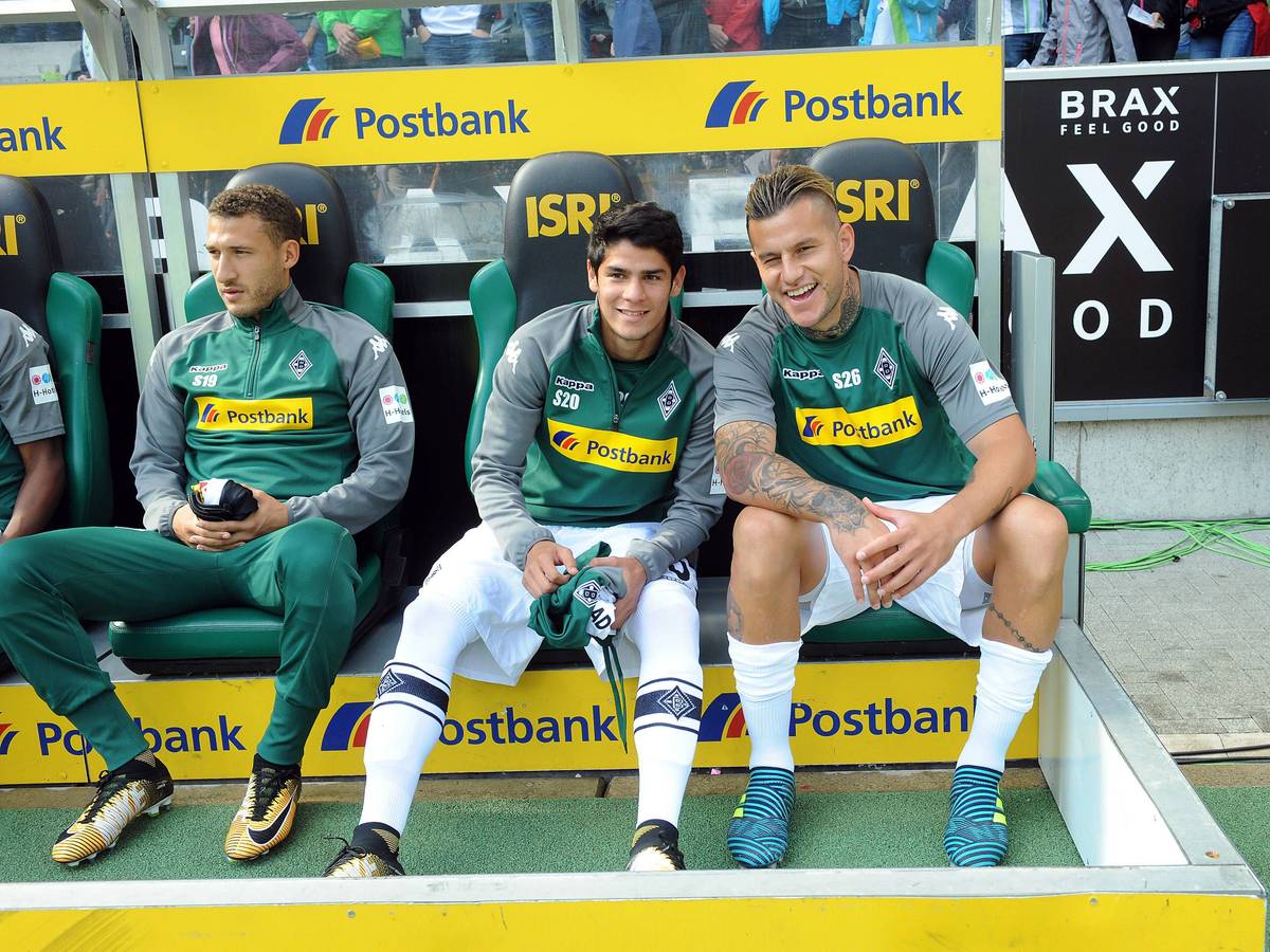 Raul Bobadilla (r.) sitzt am 9. September 2017 auf der Bank im Borussia-Park neben Julio Villalba und lächelt in die Kamera. Links ist Fabian Johnson zu sehen.