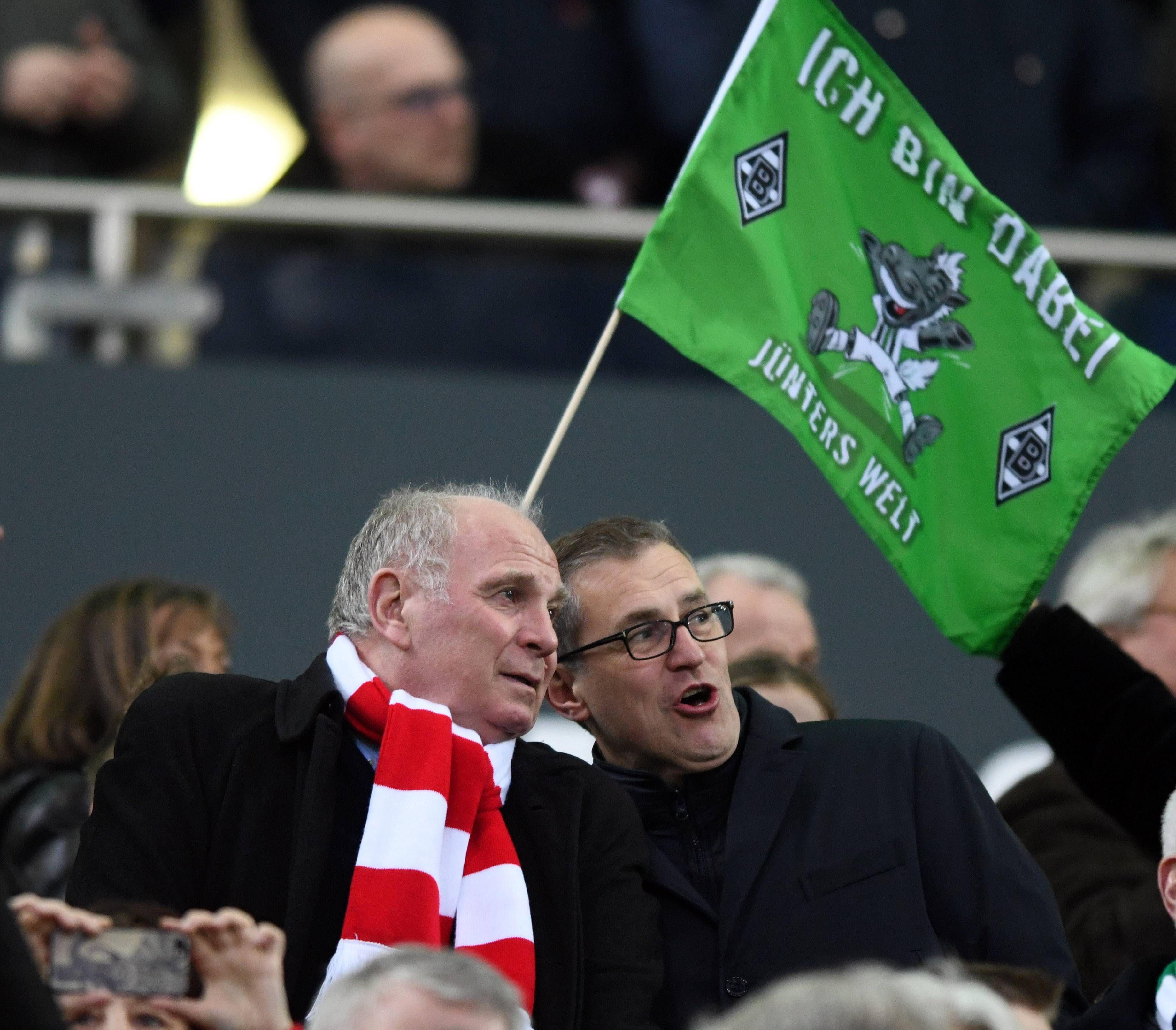 Bayern-München-Macher Uli Hoeneß (I.) beim Spiel seines FC Bayern bei Borussia Mönchengladbach im Borussia-Park am 2. März 2019. Hoeneß trägt einen rot-weißen Schal. Im Hintergrund ist eine Gladbach-Fahne zu sehen.