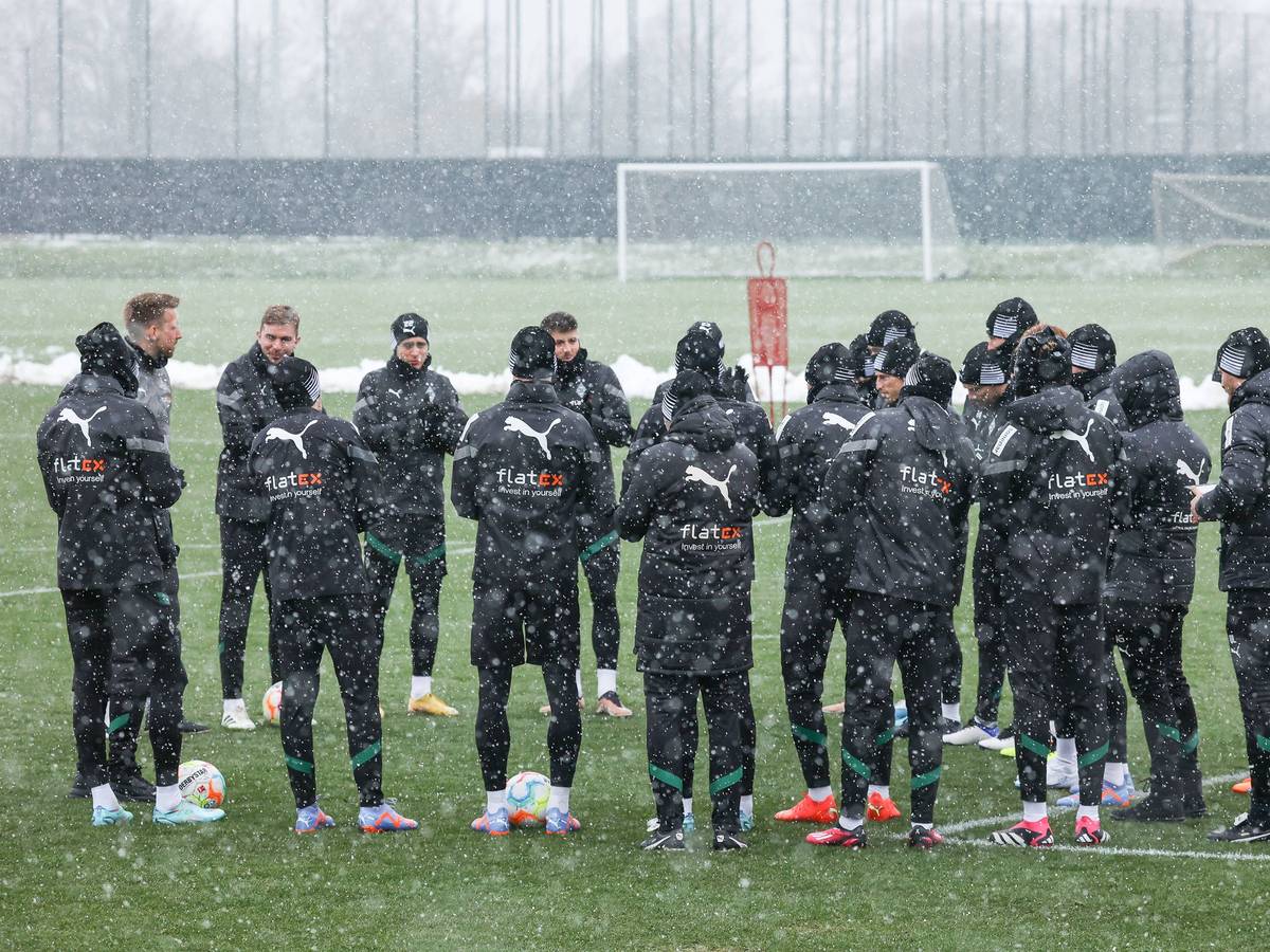 Bei dichtem Schneefall versammelt sich die Mannschaft von Borussia Mönchengladbach am 20. Januar 2023 in einem Kreis bei einer Trainingseinheit. Aufgenommen wurde das Foto auf dem Trainingsplatz im Borussia-Park.