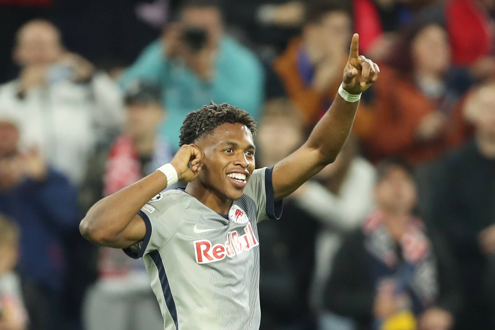 Junior Adamu bejubelt einen Treffer im Champions-League-Spiel von Red Bull Salzburg gegen den FC Chelsea am 25. Oktober 2022. Adamu fasst sich mit der rechten Hand an das rechte Ohr und zeigt mit seinem linken Zeigefinger in die Luft.