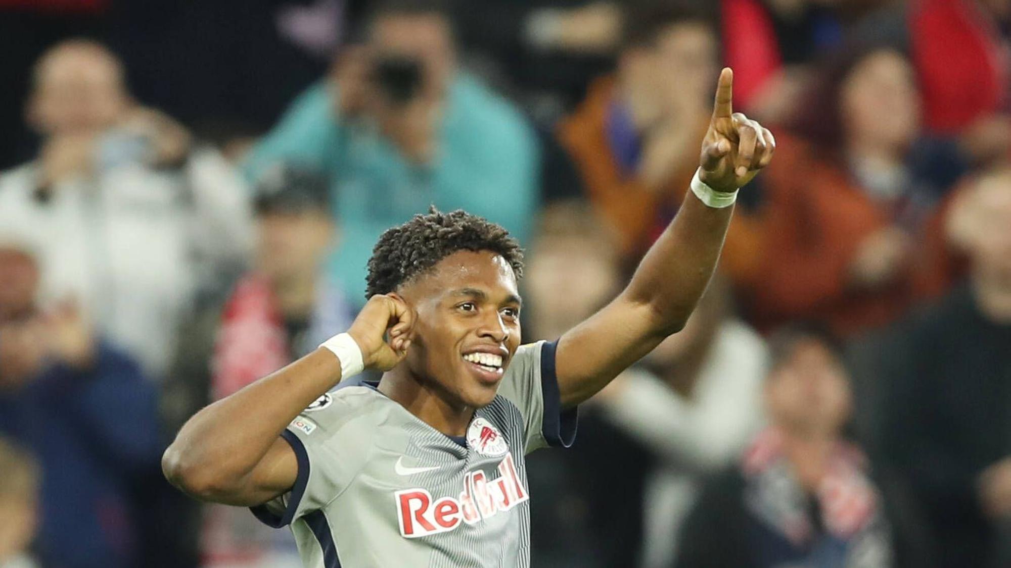 Junior Adamu bejubelt einen Treffer im Champions-League-Spiel von Red Bull Salzburg gegen den FC Chelsea am 25. Oktober 2022. Adamu fasst sich mit der rechten Hand an das rechte Ohr und zeigt mit seinem linken Zeigefinger in die Luft.