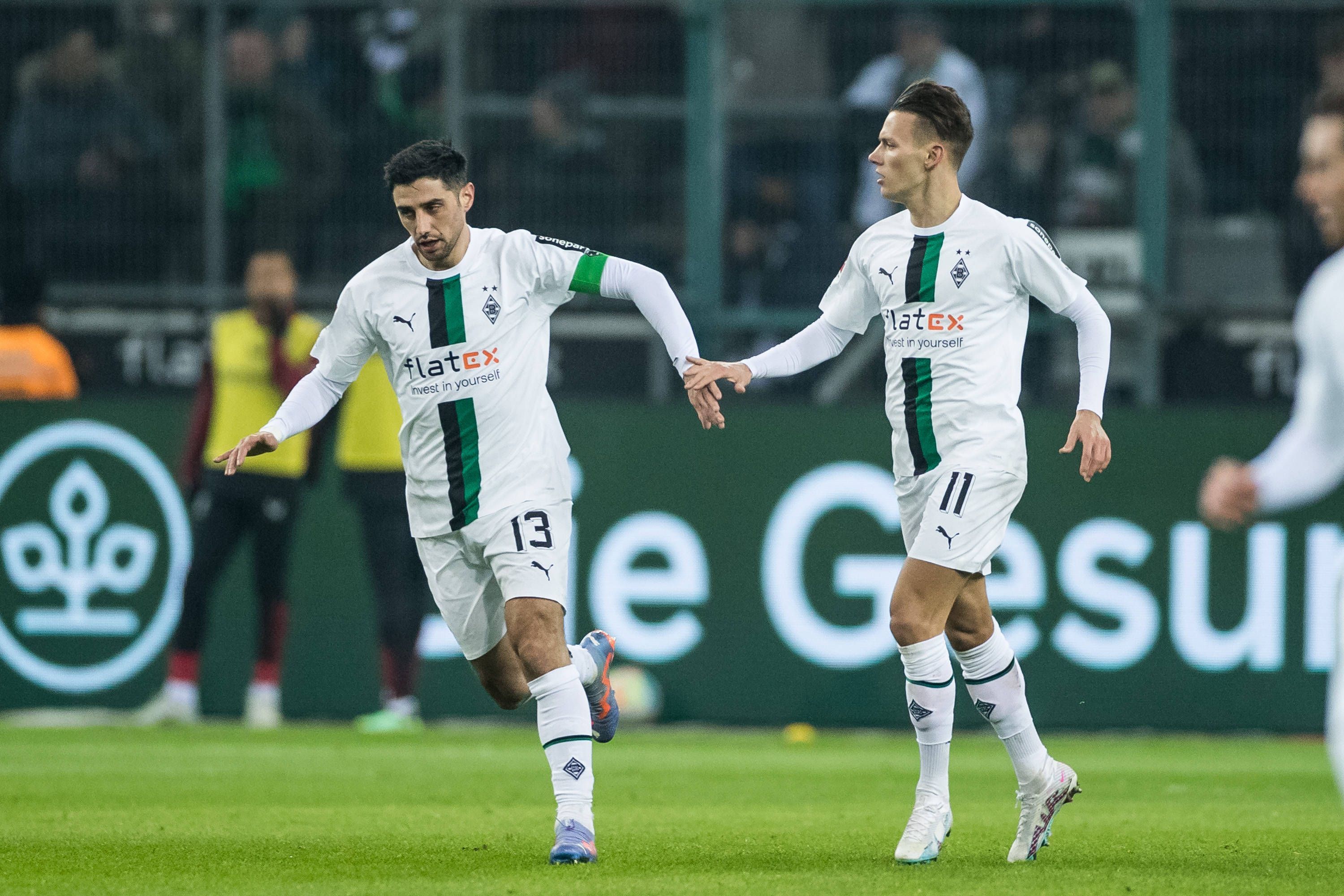 Lars Stindl (l.) und Hannes Wolf klatschen nach dem Treffer von Stindl zum 1:3 im Spiel von Borussia Mönchengladbach gegen Bayer Leverkusen im Laufen ab. Die beiden Gladbach-Spieler tragen das weiße Heimtrikot vom Borussia.