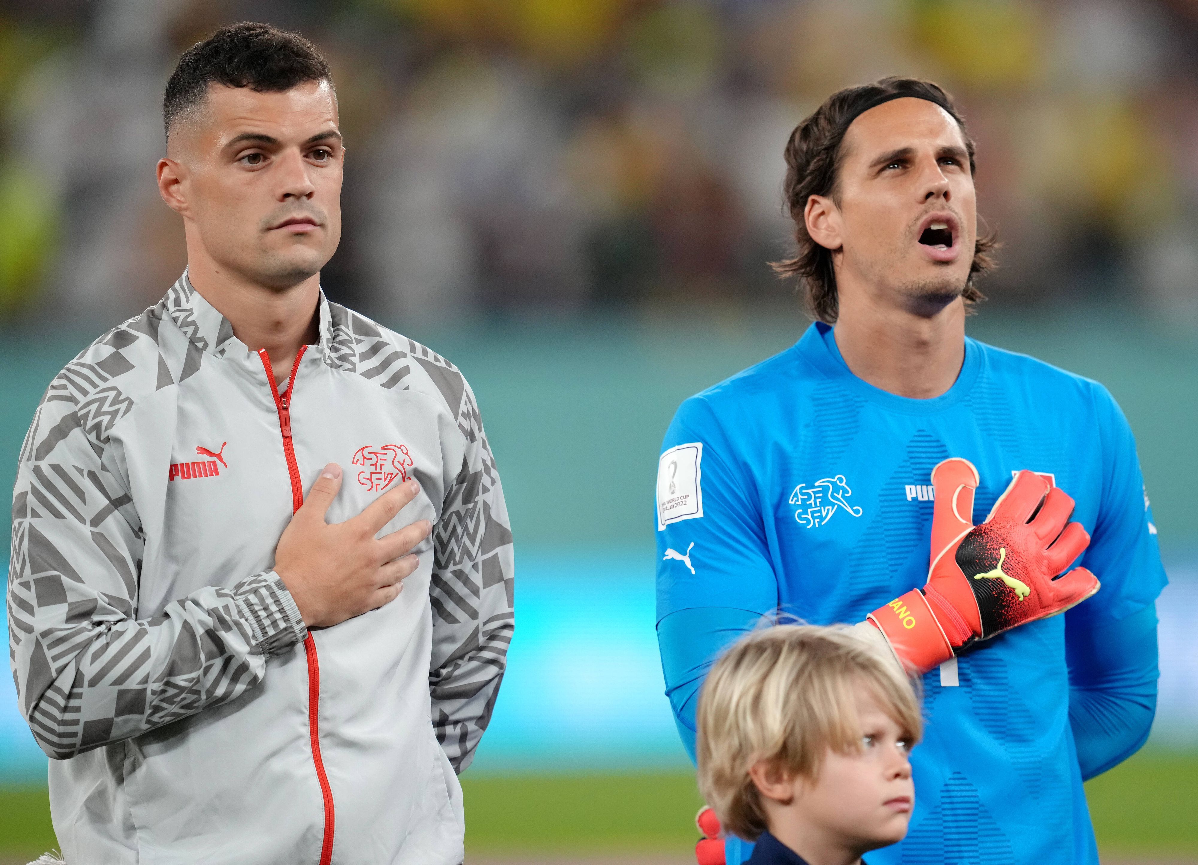 Granit Xhaka (l.) und Yann Sommer stehen vor dem WM-Spiel gegen Brasilien am 28. November 2022 nebeneinander bei der Nationalhymne. Beide Spieler der Schweiz legen ihre rechte Hand auf ihre Brust.
