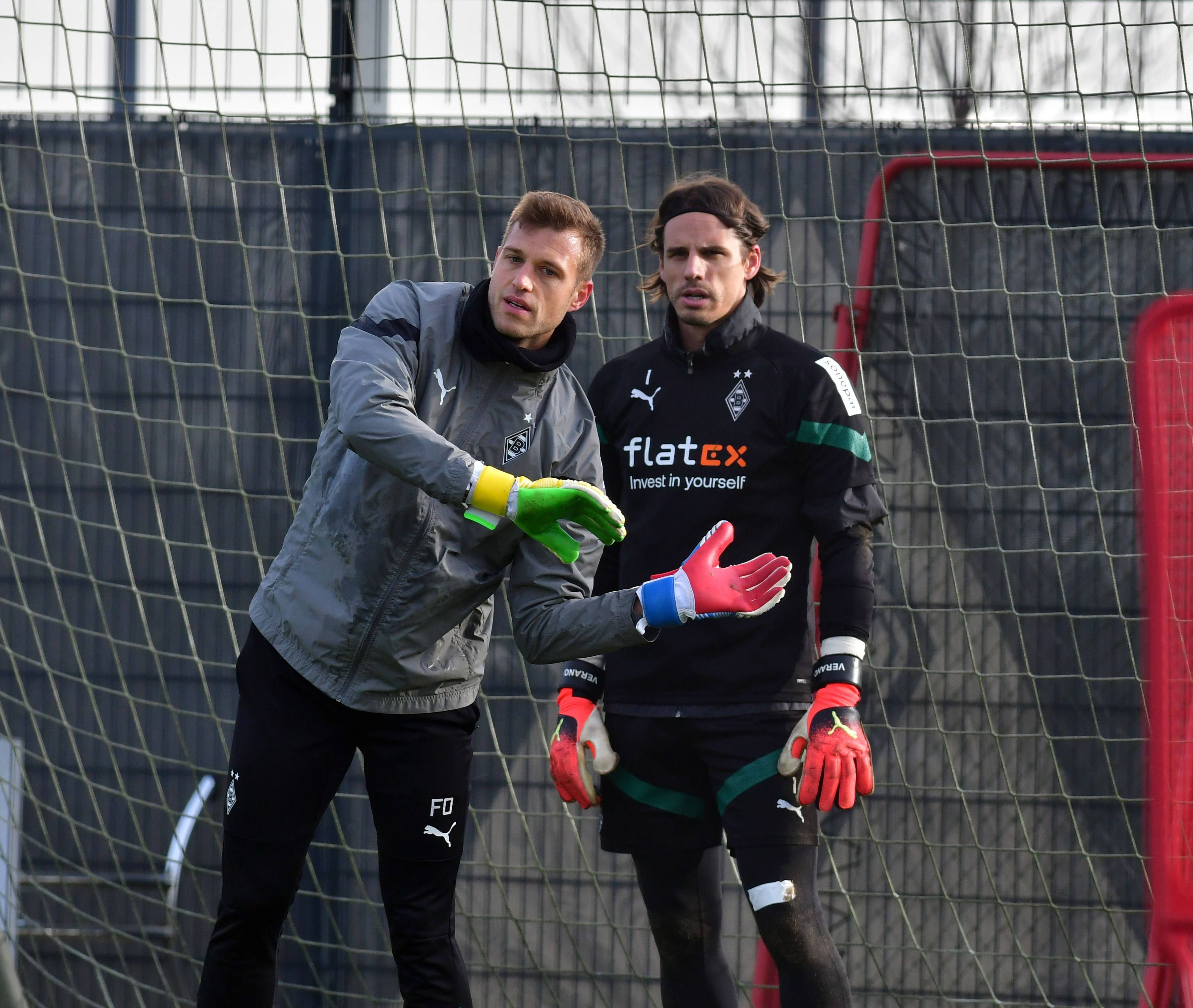 Fabian Otte (l.) macht im Training von Borussia Mönchengladbach eine Übung vor. Yann Sommer steht in Trainingskleidung neben ihm und schaut nach vorne. Otte legt seine Hände vor den Körper von Sommer, beide stehen in einem Tor.