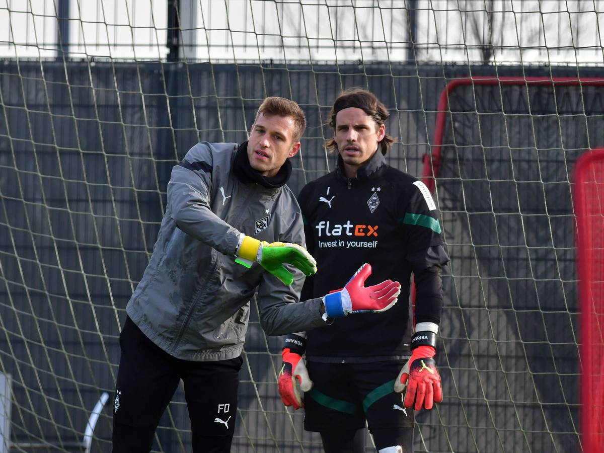 Fabian Otte (l.) macht im Training von Borussia Mönchengladbach eine Übung vor. Yann Sommer steht in Trainingskleidung neben ihm und schaut nach vorne. Otte legt seine Hände vor den Körper von Sommer, beide stehen in einem Tor.