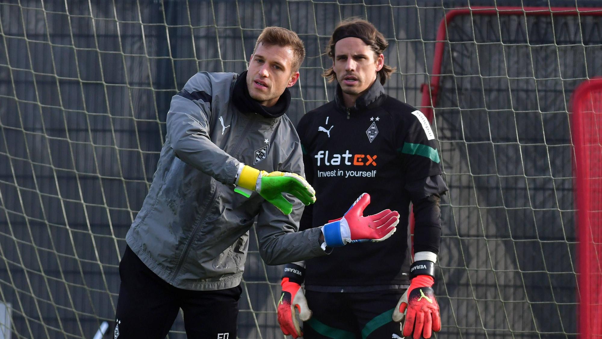 Fabian Otte (l.) macht im Training von Borussia Mönchengladbach eine Übung vor. Yann Sommer steht in Trainingskleidung neben ihm und schaut nach vorne. Otte legt seine Hände vor den Körper von Sommer, beide stehen in einem Tor.