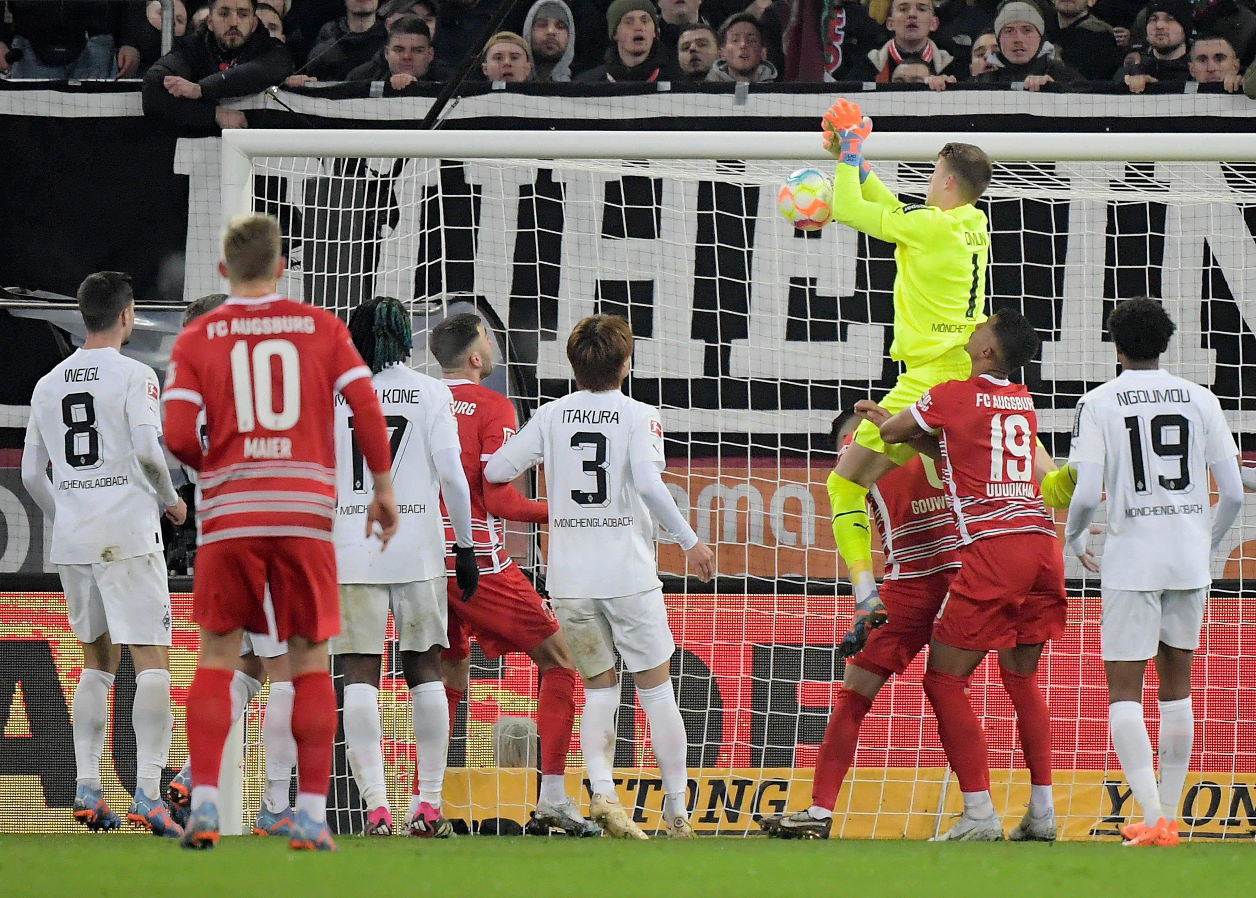 Jonas Omlin, Torwart von Borussia Mönchengladbach (in gelb), lässt den Ball fallen, Dion Beljo (verdeckt) trifft zum vermeintlichen 1:0 für den FC Augsburg. Das Tor am 25. Januar 2023 zählt aber aufgrund einer Abseitsstellung nicht.