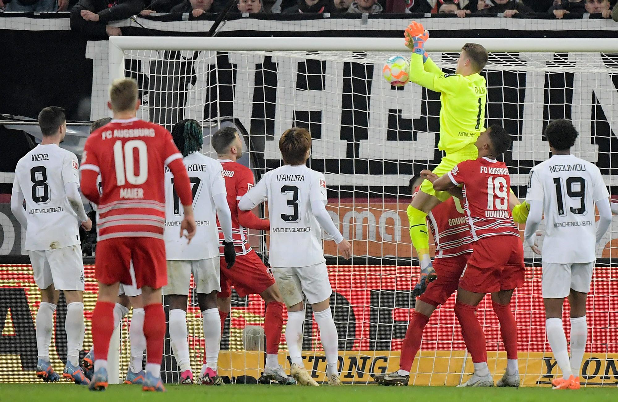 Jonas Omlin, Torwart von Borussia Mönchengladbach (in gelb), lässt den Ball fallen, Dion Beljo (verdeckt) trifft zum vermeintlichen 1:0 für den FC Augsburg. Das Tor am 25. Januar 2023 zählt aber aufgrund einer Abseitsstellung nicht.