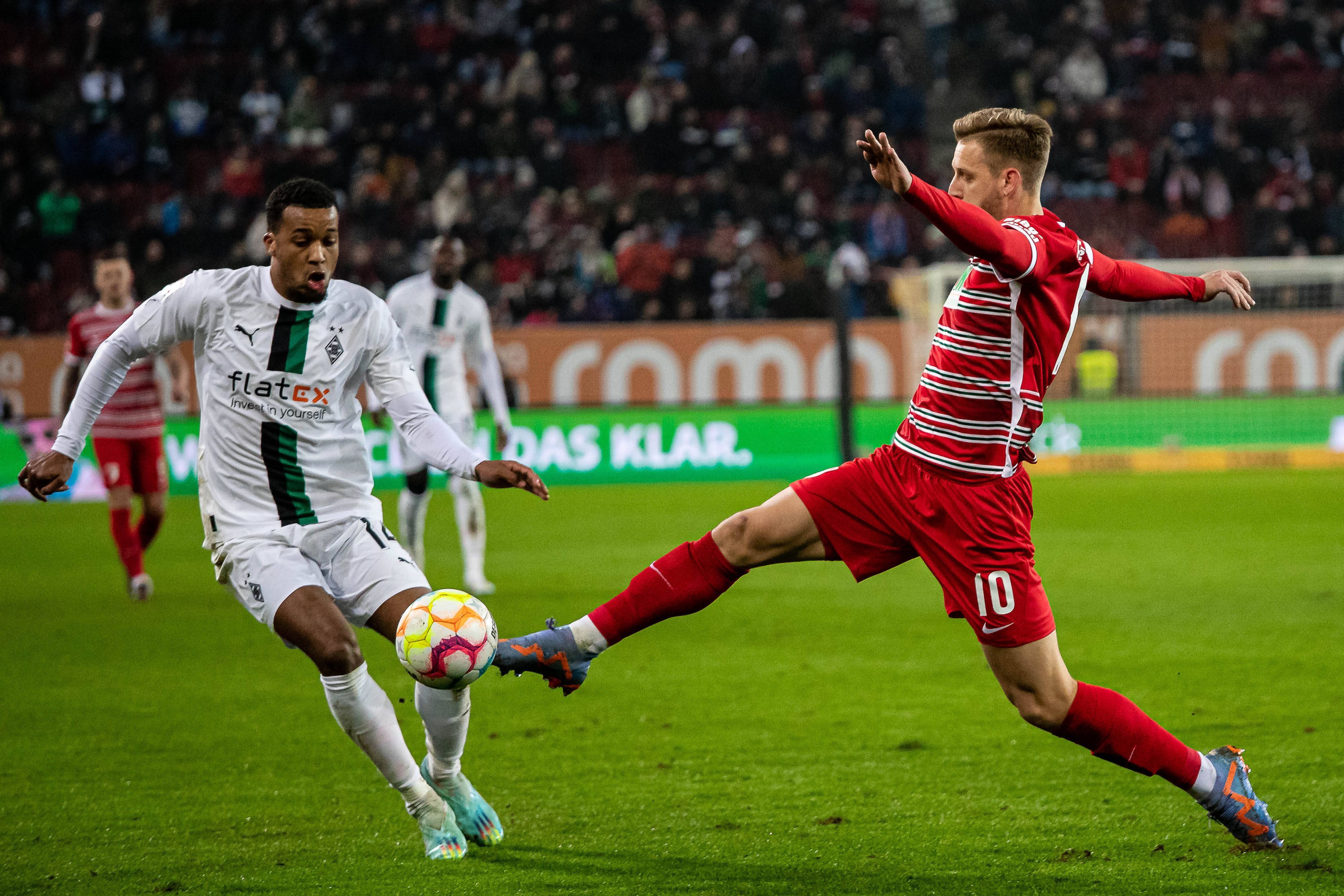 Die Fohlen haben am Mittwoch (25. Januar 2023)  ein 0:1 beim FC Augsburg kassiert. Das Foto zeigt Alassane Plea (l.) von Borussia Mönchengladbach, hier beim Zweikampf mit Arne Maier (r.) vom FCA.