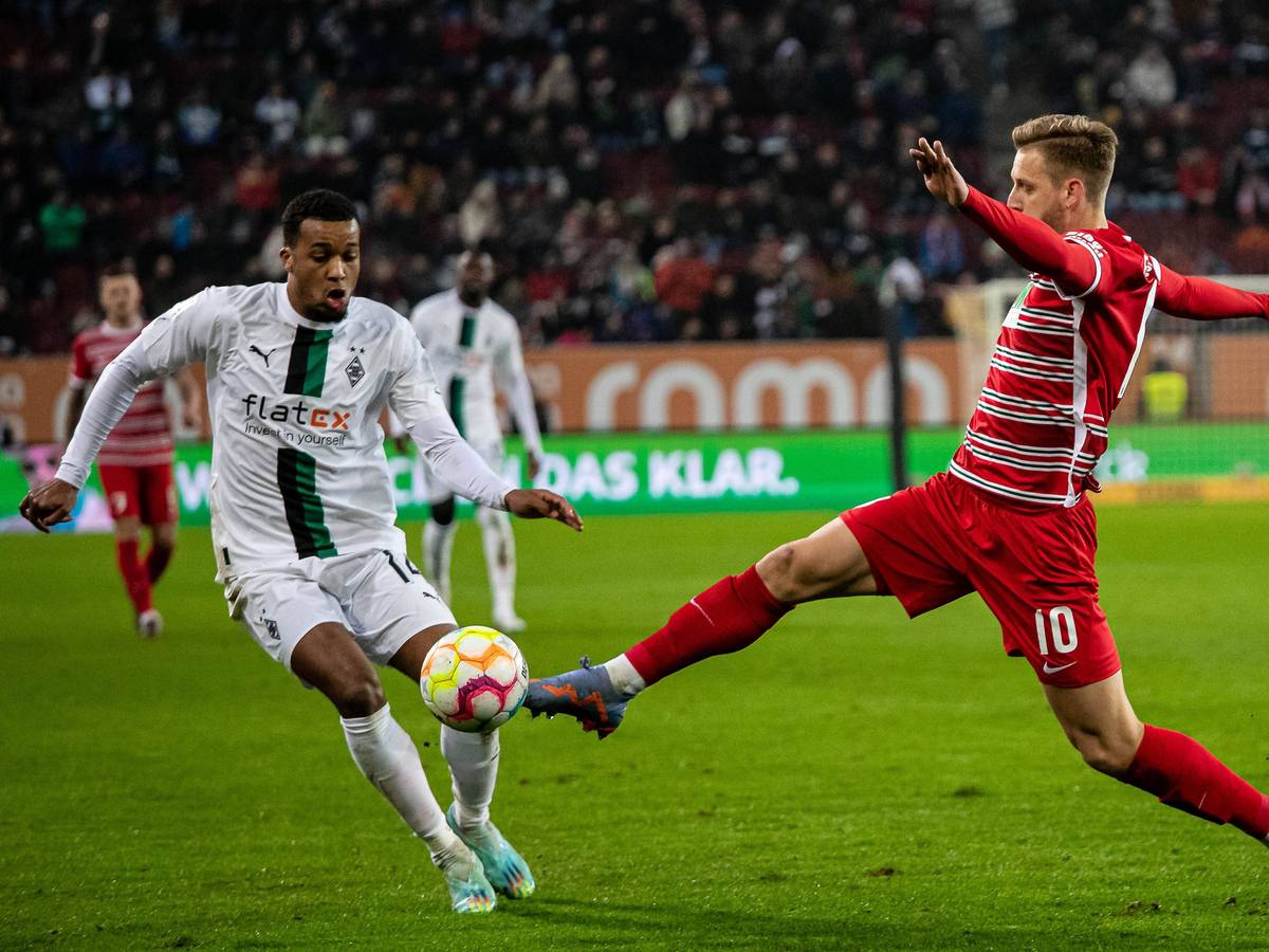 Die Fohlen haben am Mittwoch (25. Januar 2023) ein 0:1 beim FC Augsburg kassiert. Das Foto zeigt Alassane Plea (l.) von Borussia Mönchengladbach, hier beim Zweikampf mit Arne Maier (r.) vom FCA.
