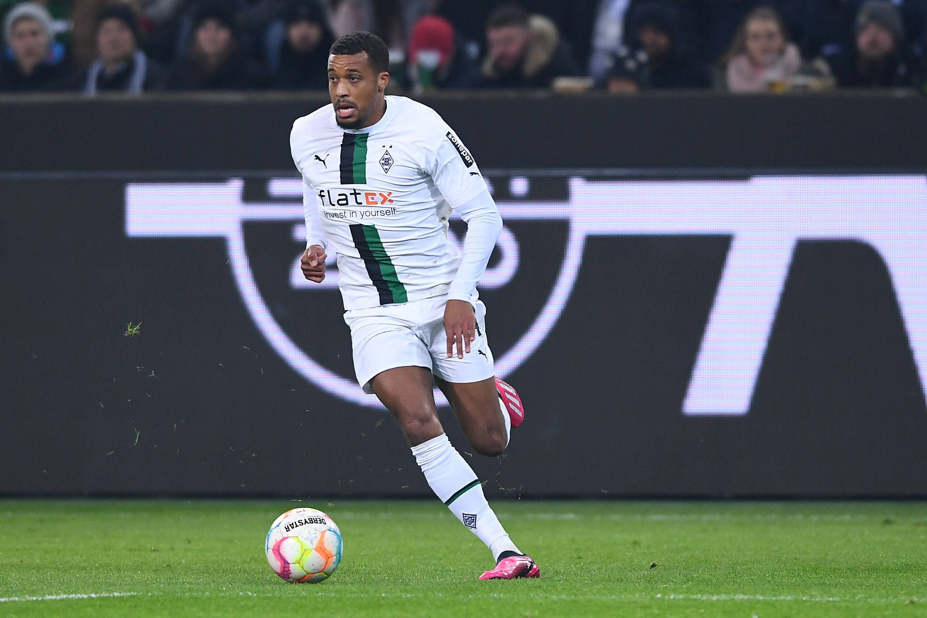 Alassane Plea läuft mit dem Ball am Fuß über den Rasen im Borussia Park. Aufgenommen wurde das Foto am 22. Januar 2023 beim Bundesliga-Spiel von Borussia Mönchengladbach gegen Bayer Leverkusen, Plea trägt das weiße Gladbach-Heimtrikot.