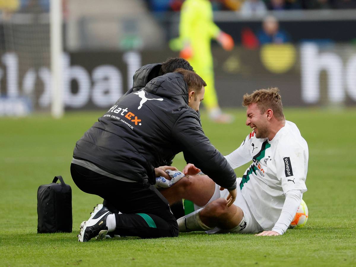 Das tut weh! Christoph Kramer (r.) von Borussia Mönchengladbach ist beim Bundesliga-Duell in Hoffenheim (28. Januar 2023) übel gefoult worden. In dieser Szene wird er behandelt. Er sitzt auf dem Rasen.
