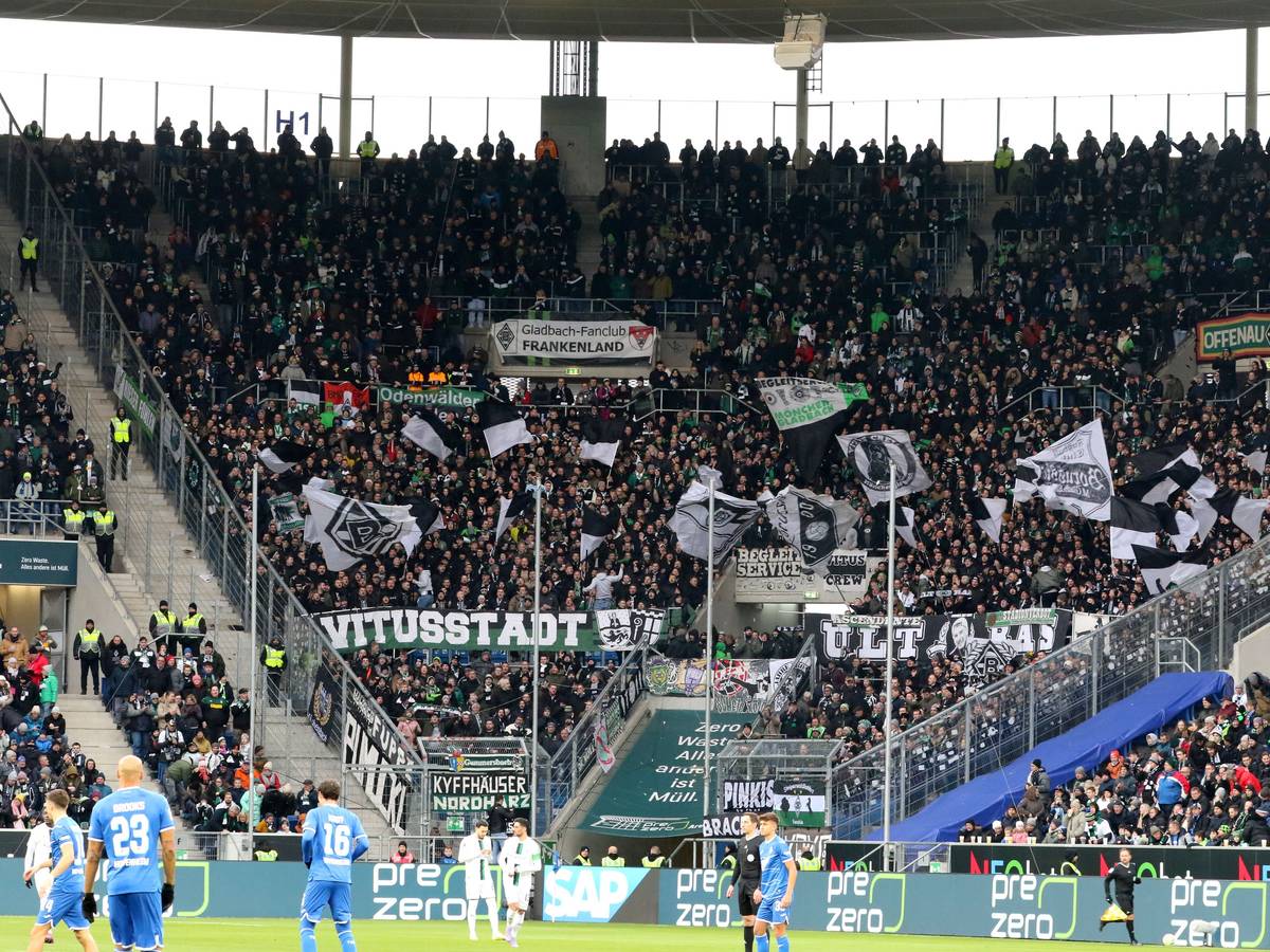 Der Fan-Block von Borussia Mönchengladbach während des Bundesliga-Spiels (28. Januar 2023) bei der TSG Hoffenheim in der Sinsheimer Arena. Zu sehen sind Banner der Gladbach-Ultras und Fahnen.