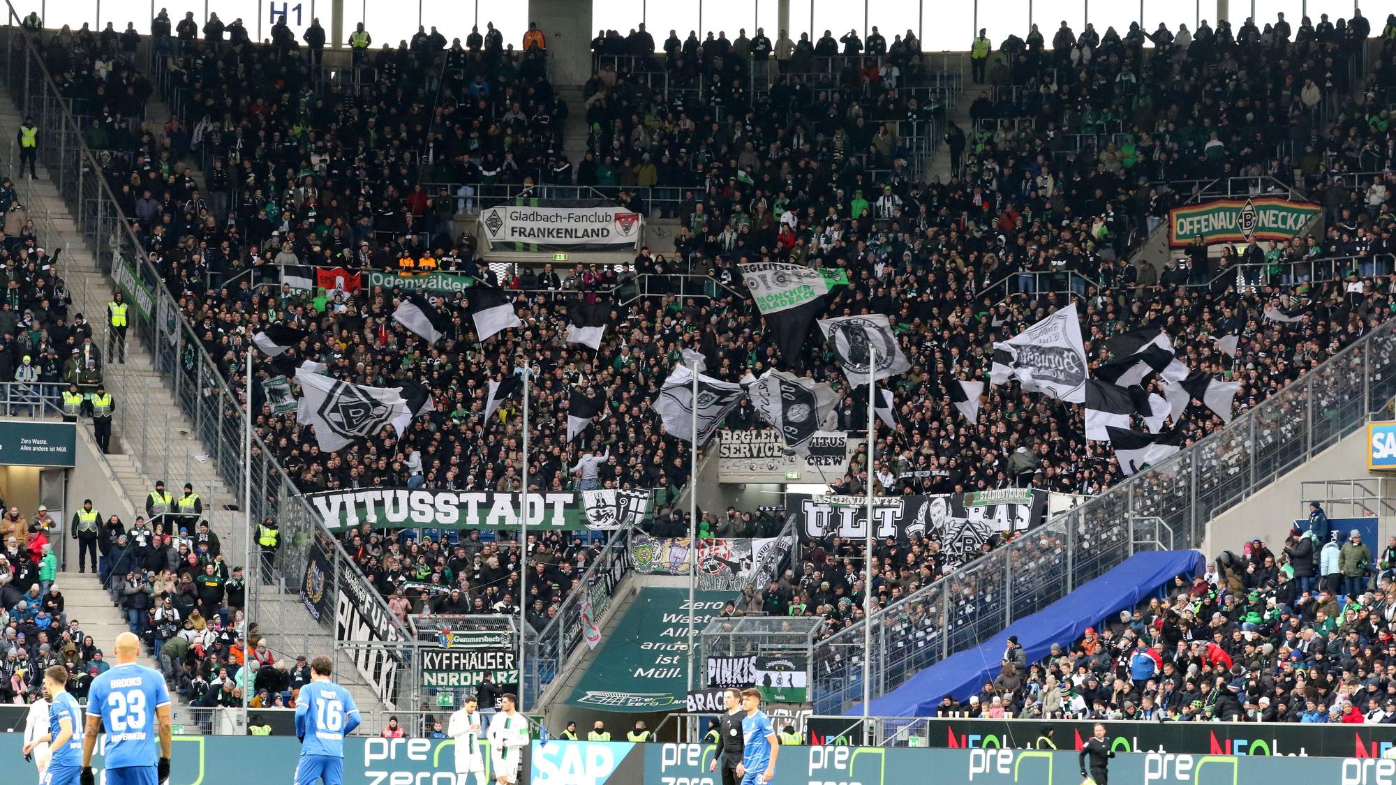 Der Fan-Block von Borussia Mönchengladbach während des Bundesliga-Spiels (28. Januar 2023) bei der TSG Hoffenheim in der Sinsheimer Arena. Zu sehen sind Banner der Gladbach-Ultras und Fahnen.