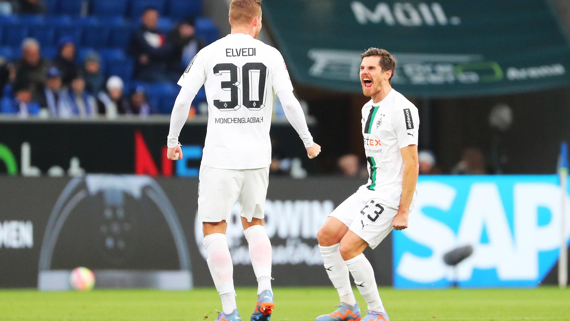 Jonas Hofmann (r.) von Borussia Mönchengladbach, hier beim Jubel mit Nico Elvedi (l.) beim Match in Hoffenheim am 28. Januar 2023. Er schreit dabei und geht etwas in die Knie.