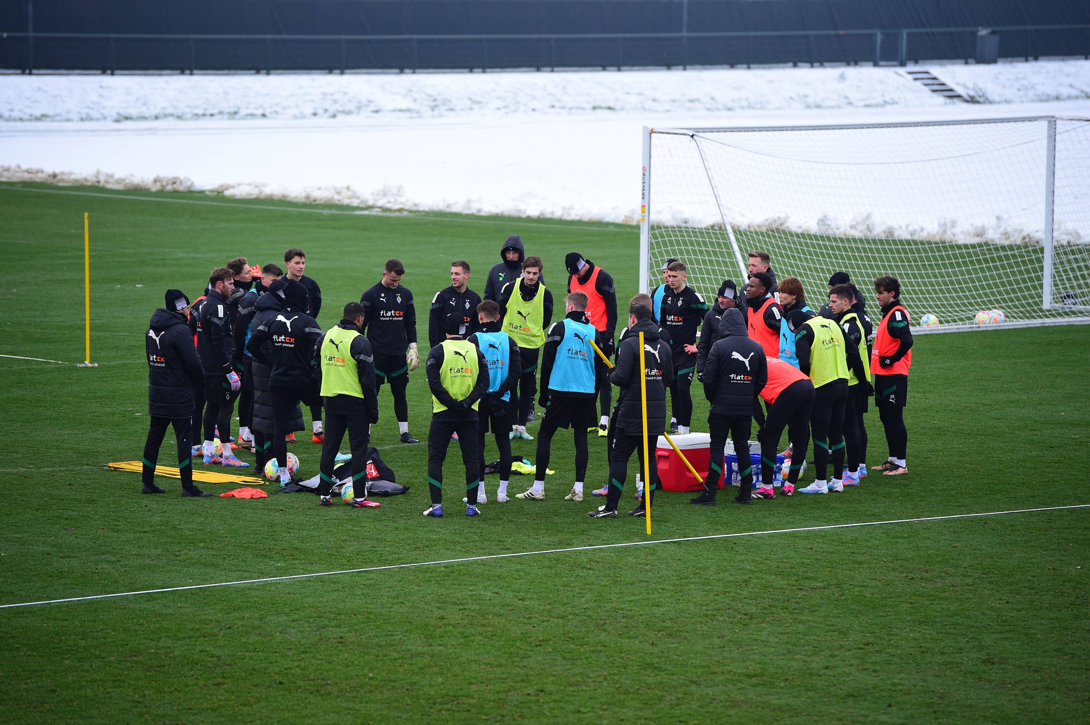 Das Team von Borussia Mönchengladbach hier bei einer Trainingseinheit am 19. Januar 2023 im Kreis stehend in bunten Leibchen.