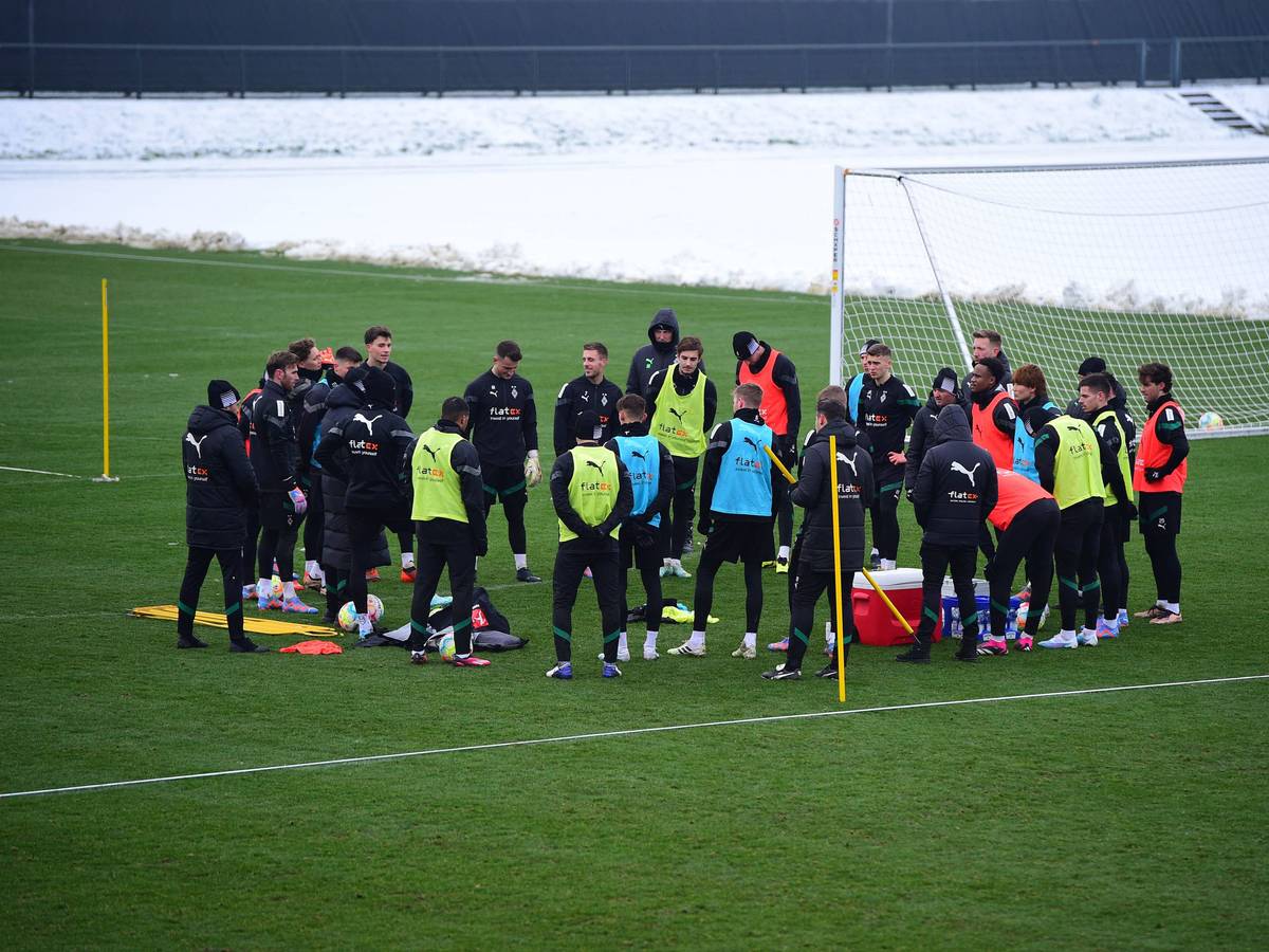 Das Team von Borussia Mönchengladbach hier bei einer Trainingseinheit am 19. Januar 2023 im Kreis stehend in bunten Leibchen.