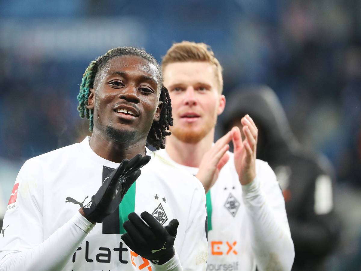 Gute Laune bei Manu Koné von Borussia Mönchengladbach. Der Franzose feierte am Samstag (28. Januar 2023) mit seinem Team einen 4:1-Sieg bei der TSG 1899 Hoffenheim. Das Foto zeigt ihn im weißen langärmligen Trikot und schwarzen Handschuhen in die Hände klatschend.