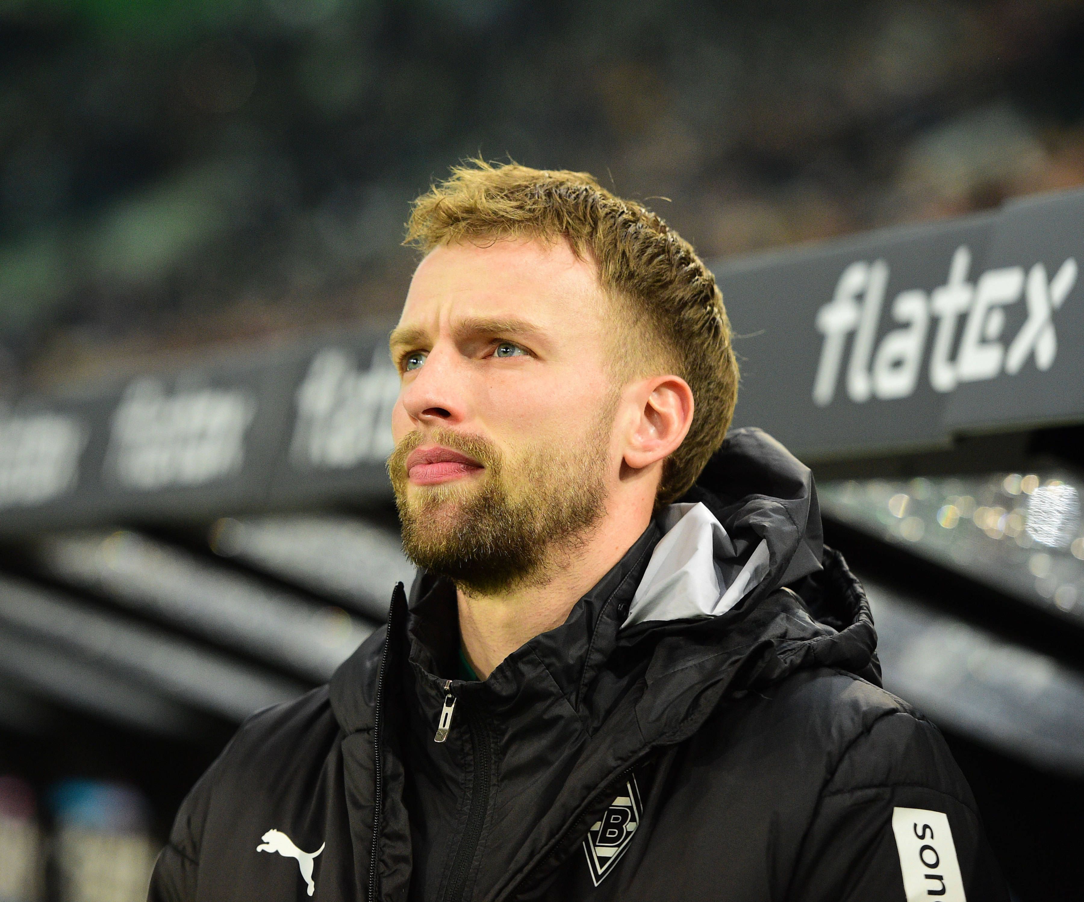 Gladbach-Verteidiger Marvin Friedrich, hier zu sehen am 22. Januar 2023 im Borussia-Park. Friedrich trägt Trainingskluft und blickt von der Bank Richtung Spielfeld.