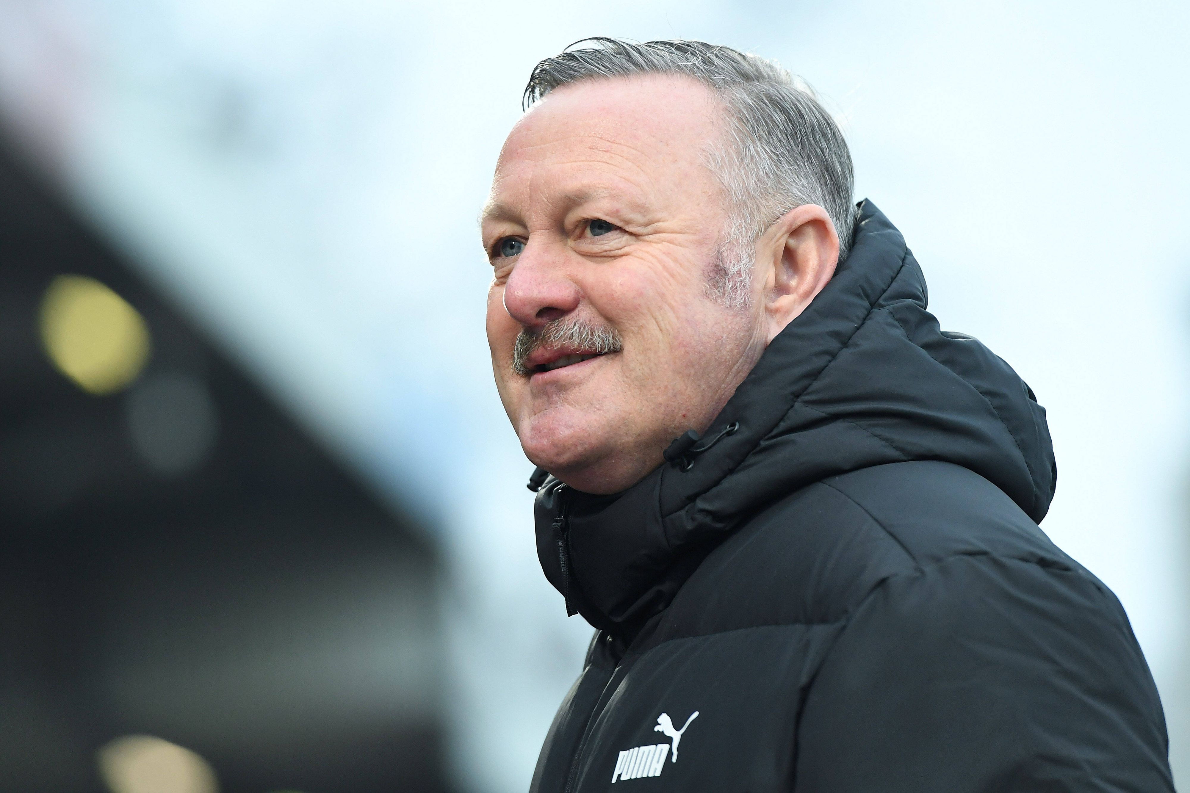 Roland Virkus ist Sportdirektor bei Borussia Mönchengladbach. Dieses Foto zeigt den 56-Jährigen am 3. Dezember 2022 im Stadion Niederrhein in Oberhausen. Virkus lächelt und blickt zur Seite.