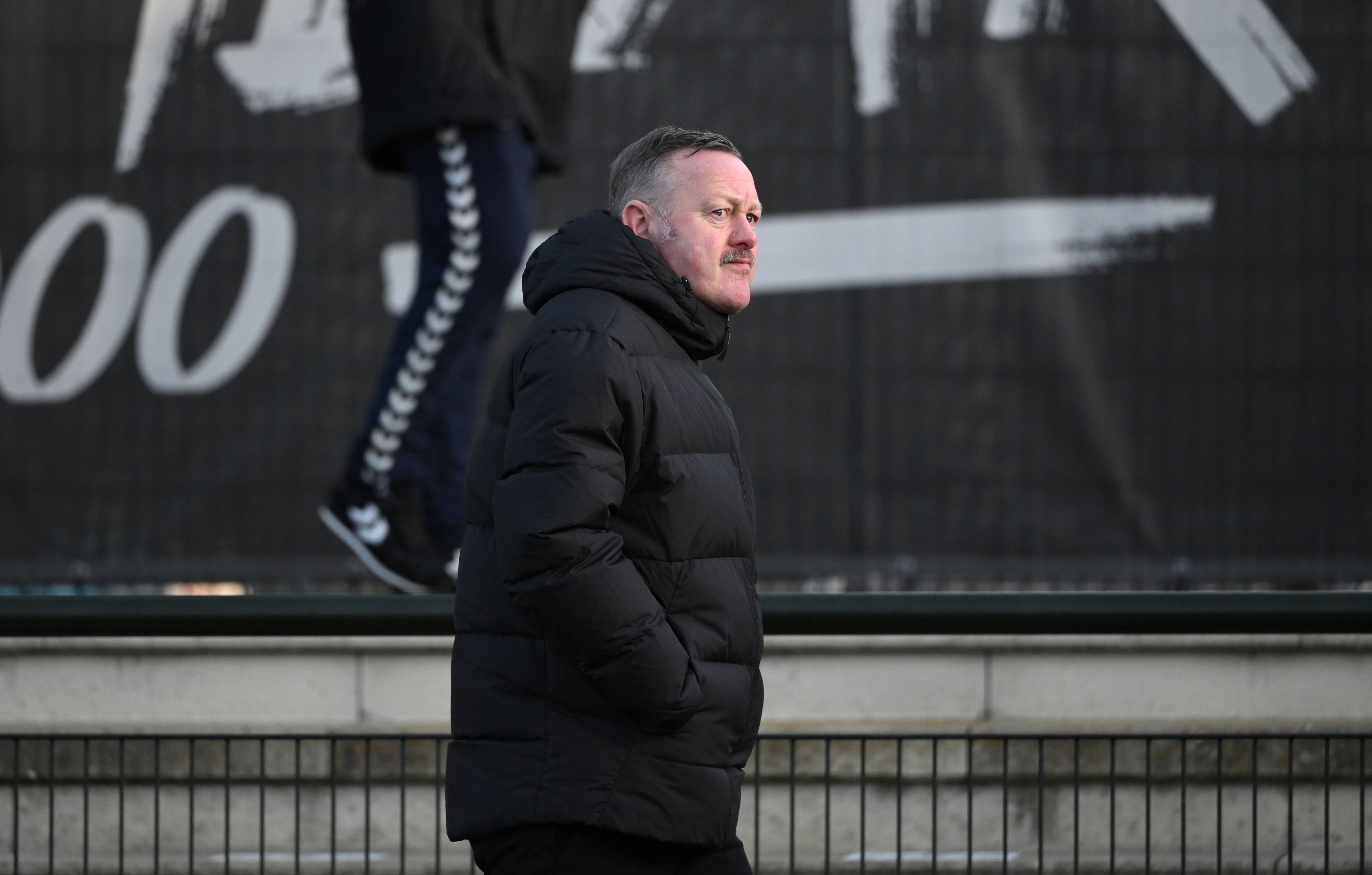 Roland Virkus geht am 7. Januar 2023 am Spielfeldrand des Fohlenplatz von Borussia Mönchengladbach entlang. Der Sportdirektor von Borussia Mönchengladbach trägt eine schwarze Winterjacke.