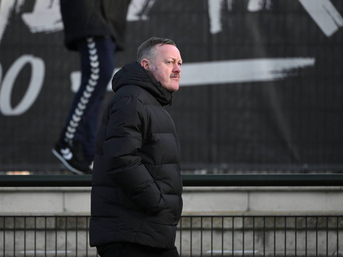 Roland Virkus geht am 7. Januar 2023 am Spielfeldrand des Fohlenplatz von Borussia Mönchengladbach entlang. Der Sportdirektor von Borussia Mönchengladbach trägt eine schwarze Winterjacke.