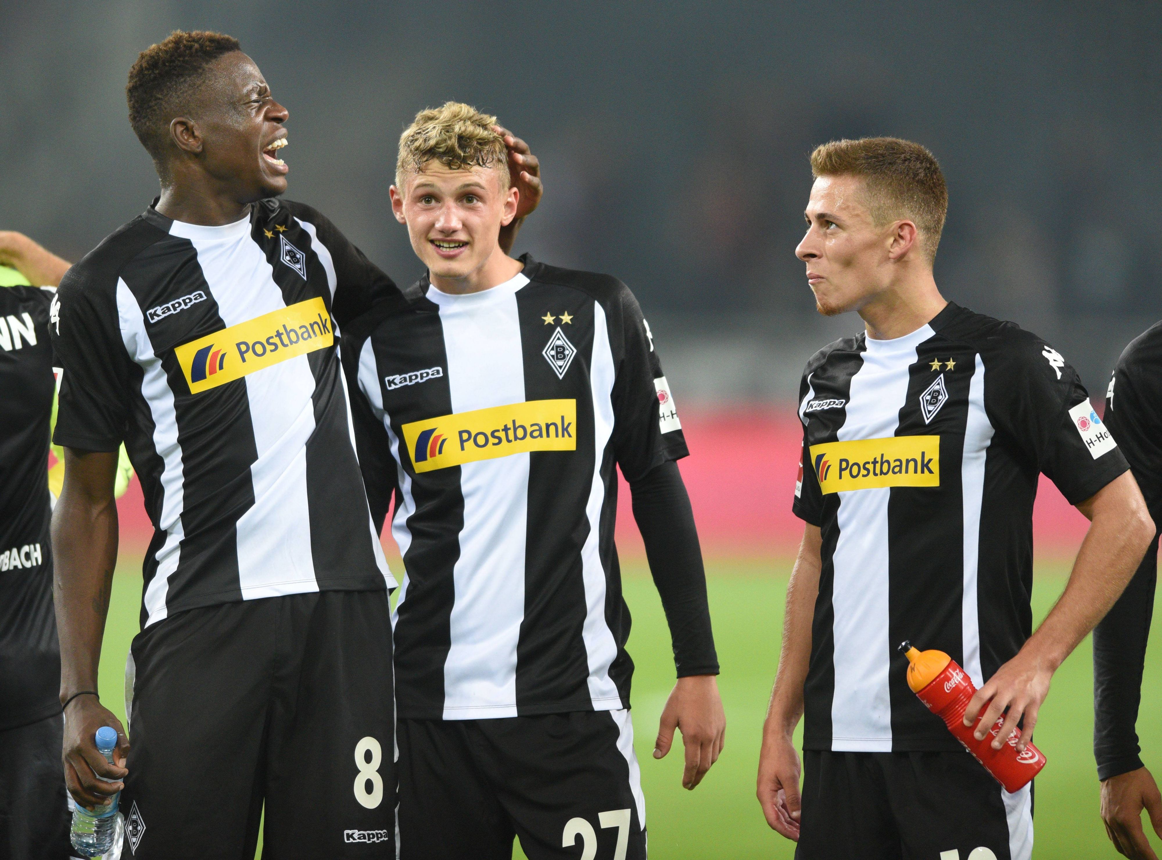 Denis Zakaria (l.), Michael Cuisance (M.) und Thorgan Hazard stehen nach dem Bundesliga-Spiel von Borussia Mönchengladbach gegen den VfB Stuttgart am 19. September 2017 in schwarz-weißen Gladbach-Trikots vor der Fankurve.