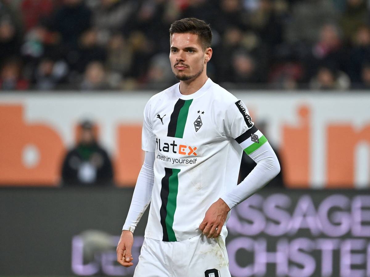 DFB-Nationalspieler Julian Weigl hat sich bei Borussia Mönchengladbach in den Fokus gespielt, auf diesem Foto trägt die Leihgabe von Benfica Lissabon die Kapitänsbinde am 25. Januar 2023 in Augsburg. Weigl schaut nach vorne, er zupft an seinem Trikot rum.