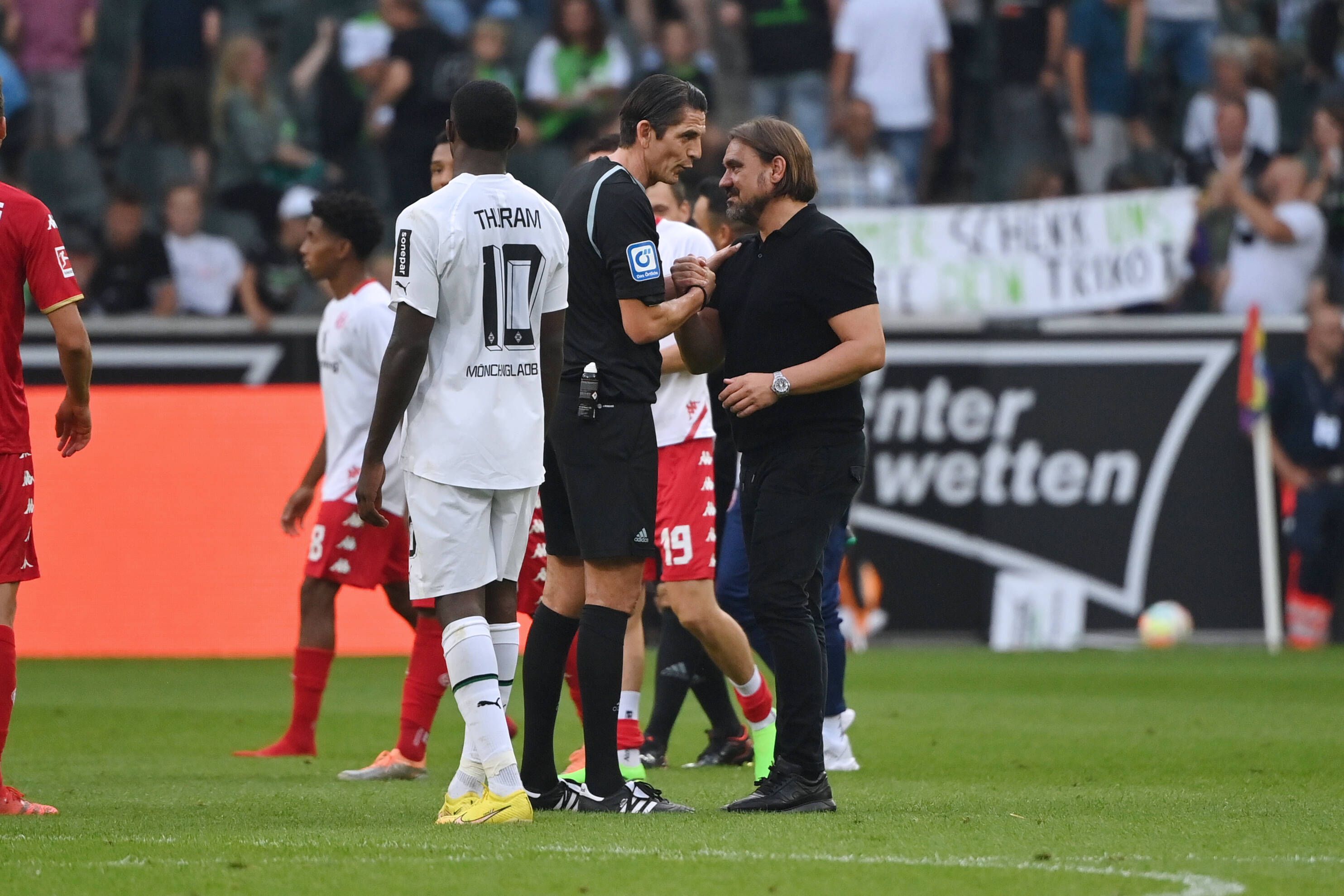 Gladbach-Trainer Daniel Farke (r.) im Gespräch mit Schiedsrichter Deniz Aytekin (l.), hier zu sehen am 4. September 2022, nach dem Bundesliga-Duell der Borussia gegen Mainz 05. Farke und Aytekin klatschen sich ab und diskutieren über einige Szenen.