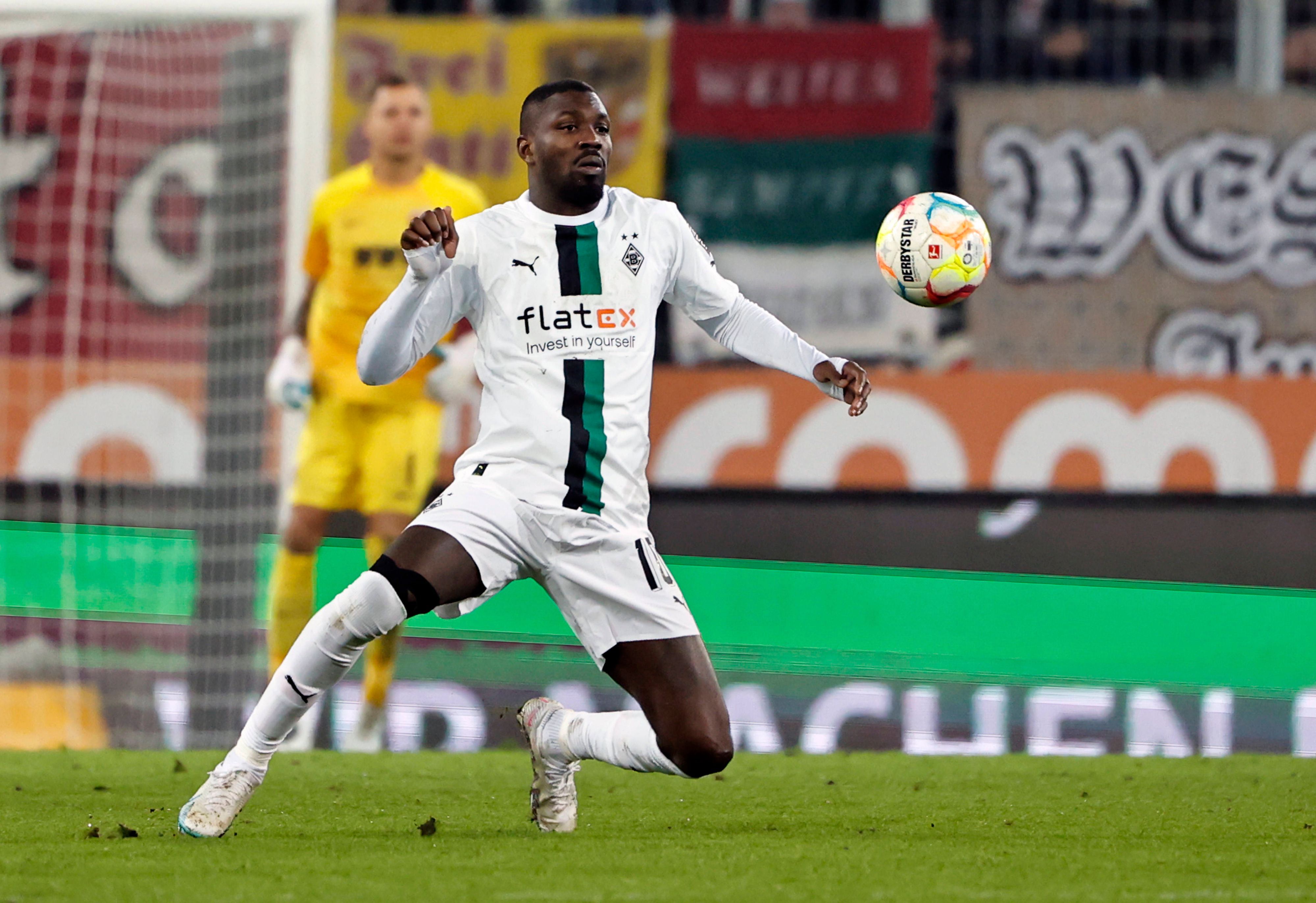 Marcus Thuram schaut im Bundesliga-Spiel von Borussia Mönchengladbach beim FC Augsburg am 25. Januar 2023 fokussiert auf den fliegenden Ball. Thuram trägt das weiße Gladbach-Heimtrikot.