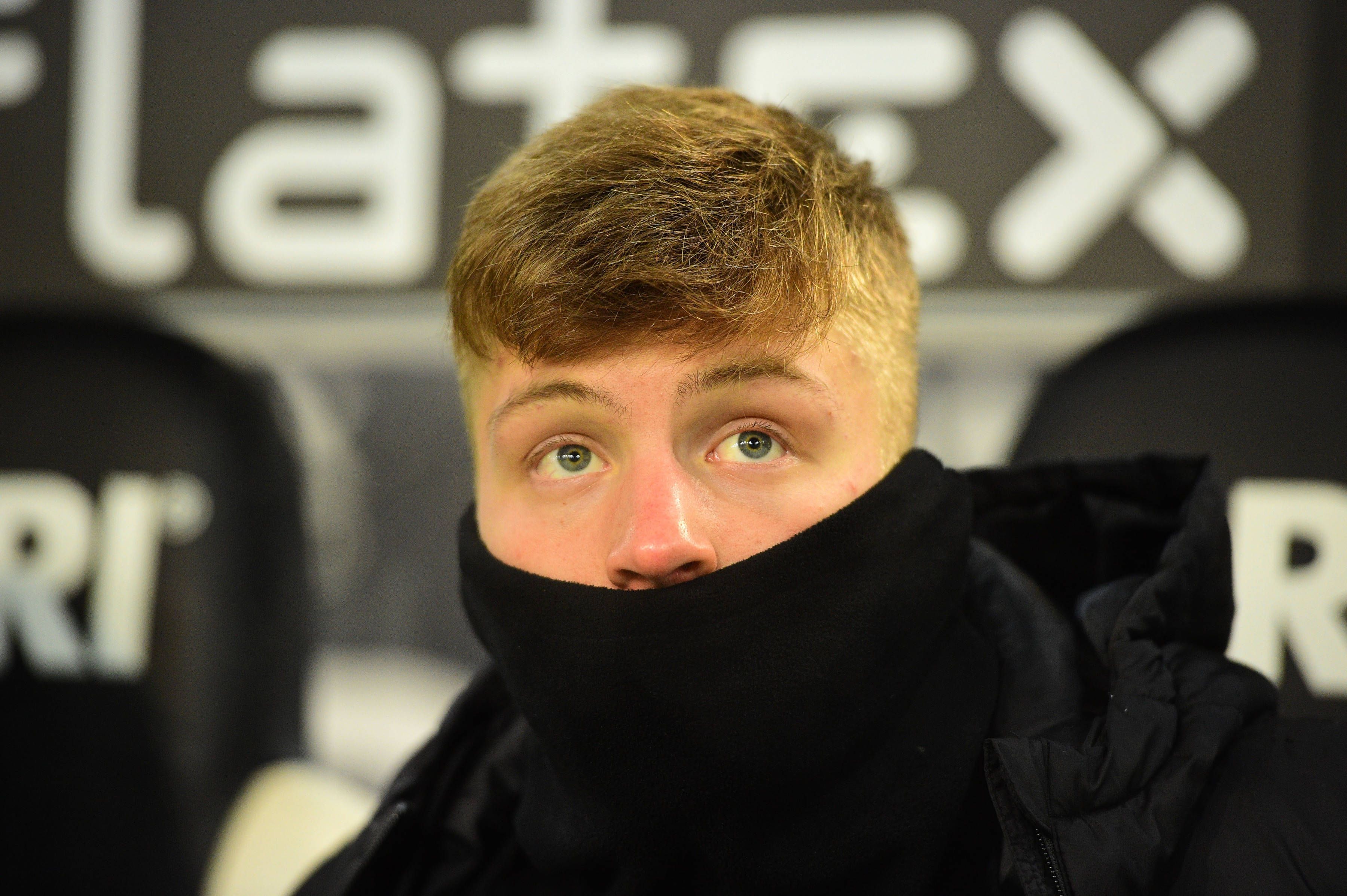 Luca Netz von Borussia Mönchengladbach, hier am 22. Januar 2023 beim Bundesliga-Spiel gegen Bayer 04 Leverkusen im Borussia-Park dick in warme Kleidung eingepackt auf der Auswechselbank. Er hat den Schal dabei über den Mund gezogen, sodass nur Nase, Augen und Haare zu sehen sind. Der rest verschwindet in der Schwarzen Kleidung.
