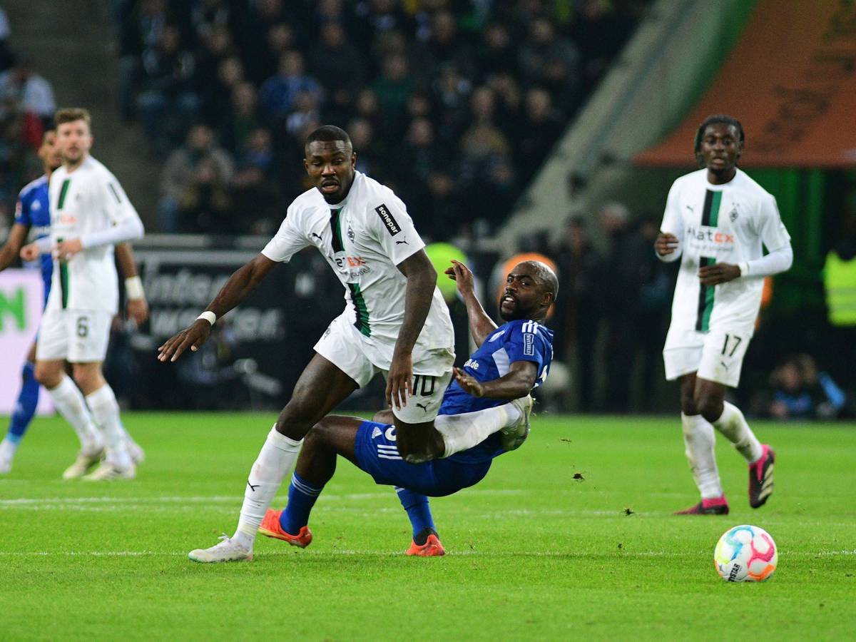 Gladbach-Stürmer Marcus Thuram (M.) im Zweikampf mit Eder Balanta von Schalke 04 während des Bundesliga-Duells am 4. Februar 2023 im Borussia-Park. Im Hintergrund schauen Koné und Kramer zu.