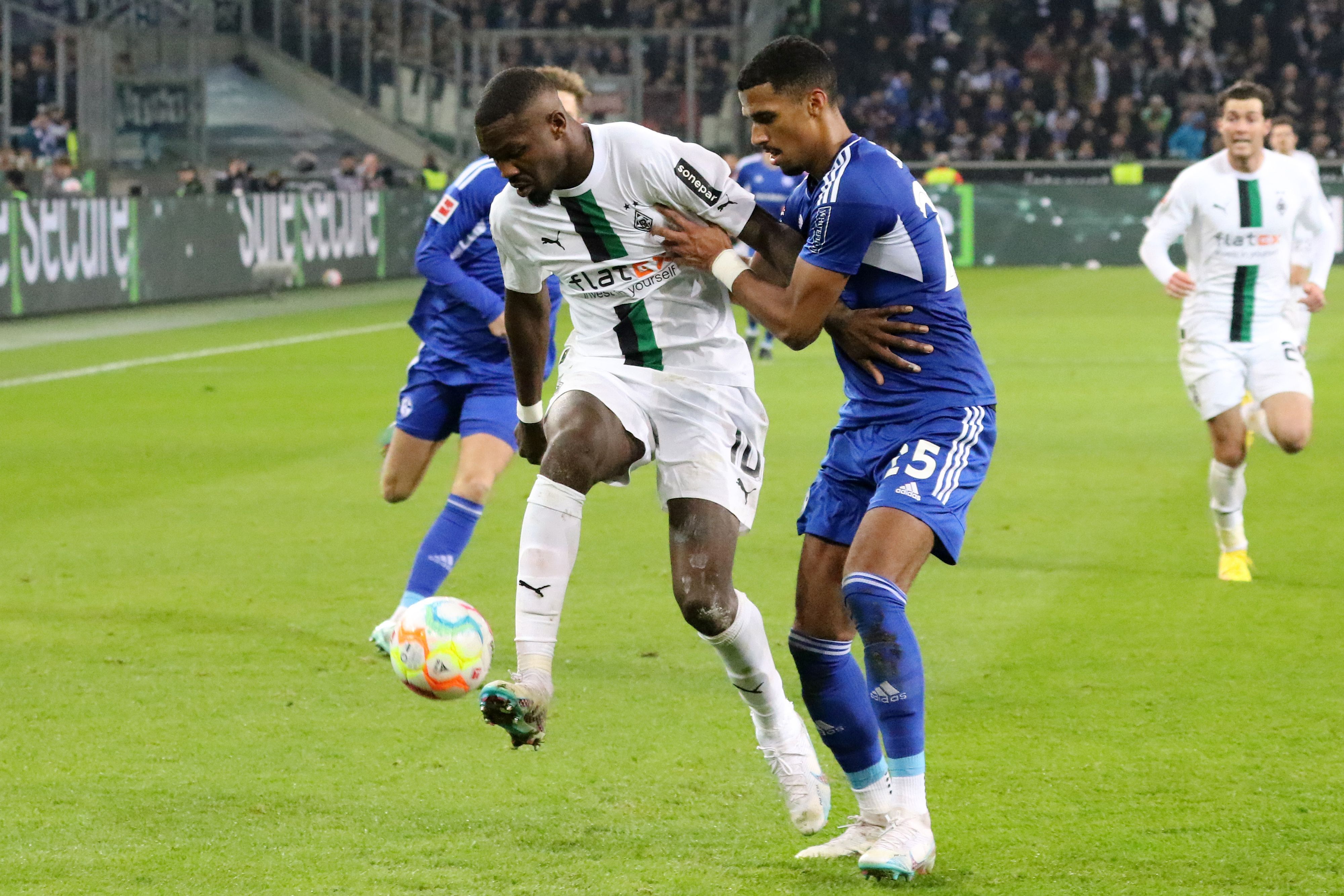 Marcus Thuram (l.), Angreifer von Borussia Mönchengladbach, am 4. Februar 2023 beim Match gegen Schalke 04 im Zweikampf mit Moritz Jenz (r.).