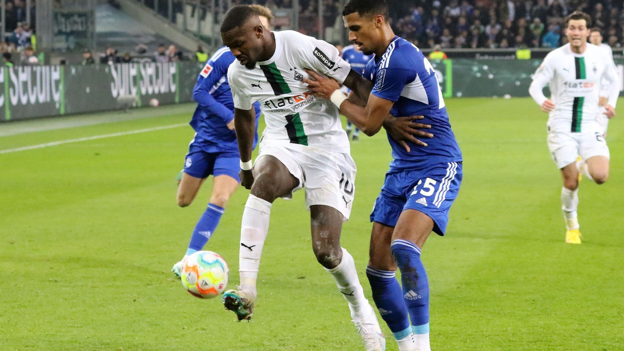 Marcus Thuram (l.), Angreifer von Borussia Mönchengladbach, am 4. Februar 2023 beim Match gegen Schalke 04 im Zweikampf mit Moritz Jenz (r.).