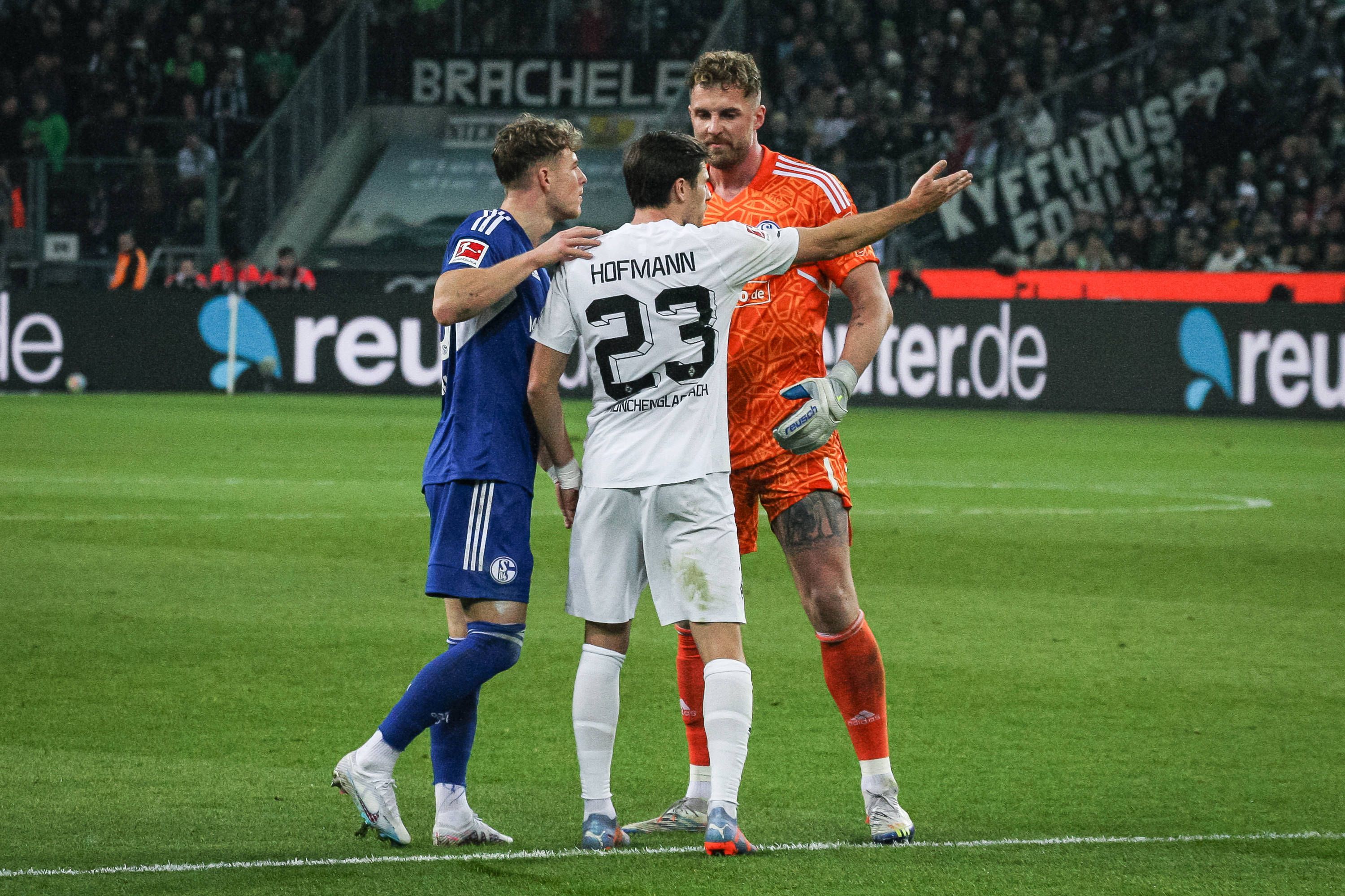 Schalke-Torwart Ralf Fährmann (r.) und Tim Skarke (l.) im Austausch mit Jonas Hofmann (M.) von Borussia Mönchengladbach während des Bundesliga-Duells (4. Februar 2023) im Borussia-Park. Hofmann macht eine Geste, Fährmann blickt ihn derweil an.
