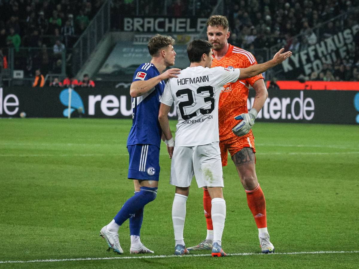 Schalke-Torwart Ralf Fährmann (r.) und Tim Skarke (l.) im Austausch mit Jonas Hofmann (M.) von Borussia Mönchengladbach während des Bundesliga-Duells (4. Februar 2023) im Borussia-Park. Hofmann macht eine Geste, Fährmann blickt ihn derweil an.