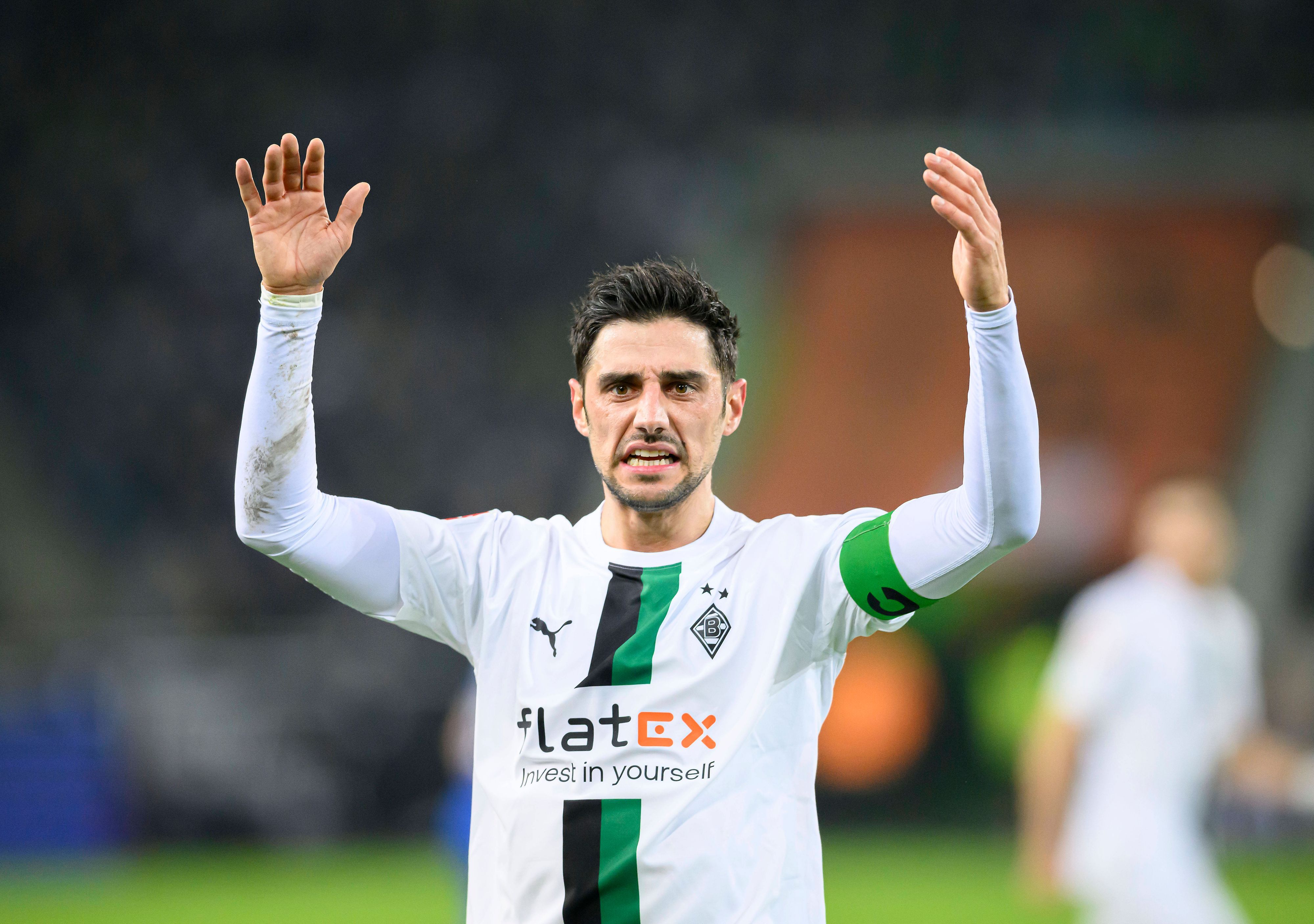 Lars Stindl, Kapitän von Borussia Mönchengladbach, reißt im Bundesliga-Spiel gegen Schalke 04 am 4. Februar 2023 beide Arme nach oben und schaut mit kritischem Blick nach vorne.