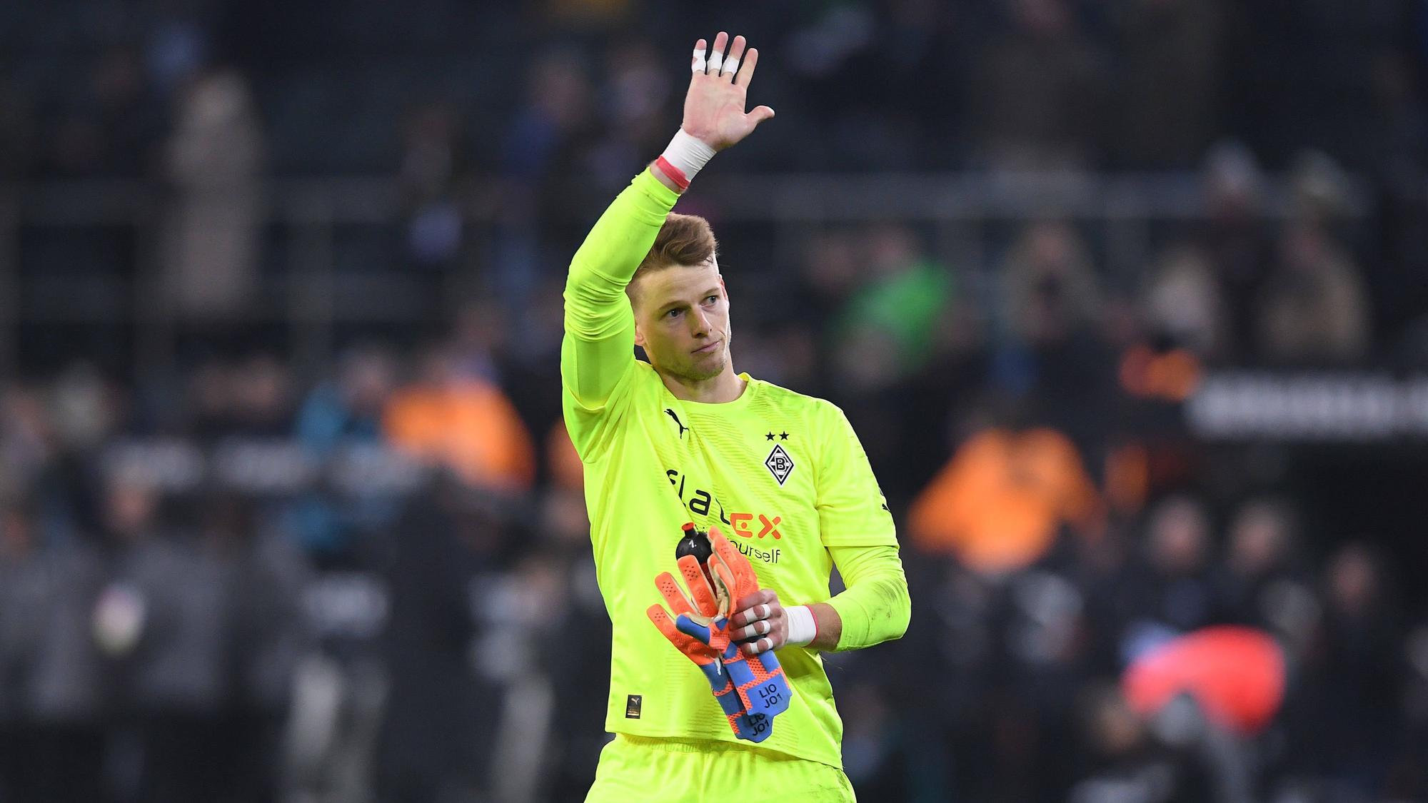 Jonas Omlin winkt nach dem Bundesliga-Spiel von Borussia Mönchengladbach gegen Schalke 04 am 4. Februar 2023 den Fans im Borussia-Park zu. Omlin trägt sein neongelbes Trikot und hält seine Torwart-Handschuhe in der linken Hand.