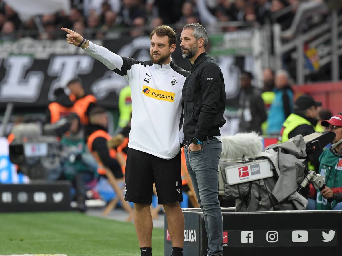 René Maric (l.) und Marco Rose stehen in der Coaching-Zone der BayArena in Leverkusen beim Bundesliga-Spiel von Borussia Mönchengladbach bei Bayer am 2. November 2019. Maric zeigt mit seinem rechten Zeigefinger nach vorne, Rose schaut zu.