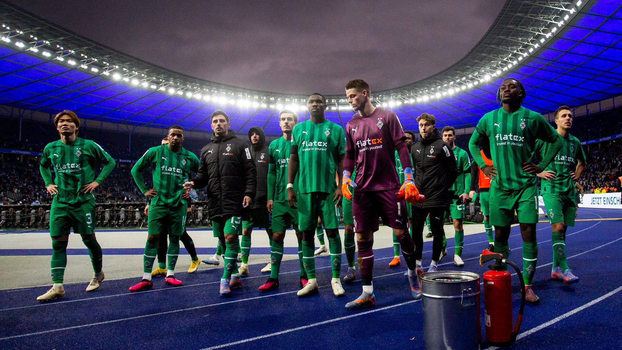 Die Spieler von Borussia Mönchengladbach sind nach der 1:4-Niederlage bei Hertha BSC am 12. Februar 2023 enttäuscht. Ko Itakura, Alassane Plea, Lars Stindl, Christoph Kramer, Florian Neuhaus, Marcus Thuram, Jonas Omlin, Jan Olschowsky, Manu Koné und Patrick Herrmann (v. l. n. r.) stehen vor der Gästekurve im Olympiastadion.