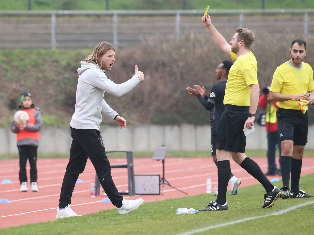 Eugen Polanski (l.) sieht beim Spiel der U23 von Borussia Mönchengladbach gegen Preußen Münster am 12. Februar 2023 die Gelbe Karte vom Schiedsrichter. Aufgenommen wurde das Foto, als Polanski die Verwarnung im Grenzlandstadion gezeigt bekommt. Polanski streckt den Daumen als Reaktion nach oben.