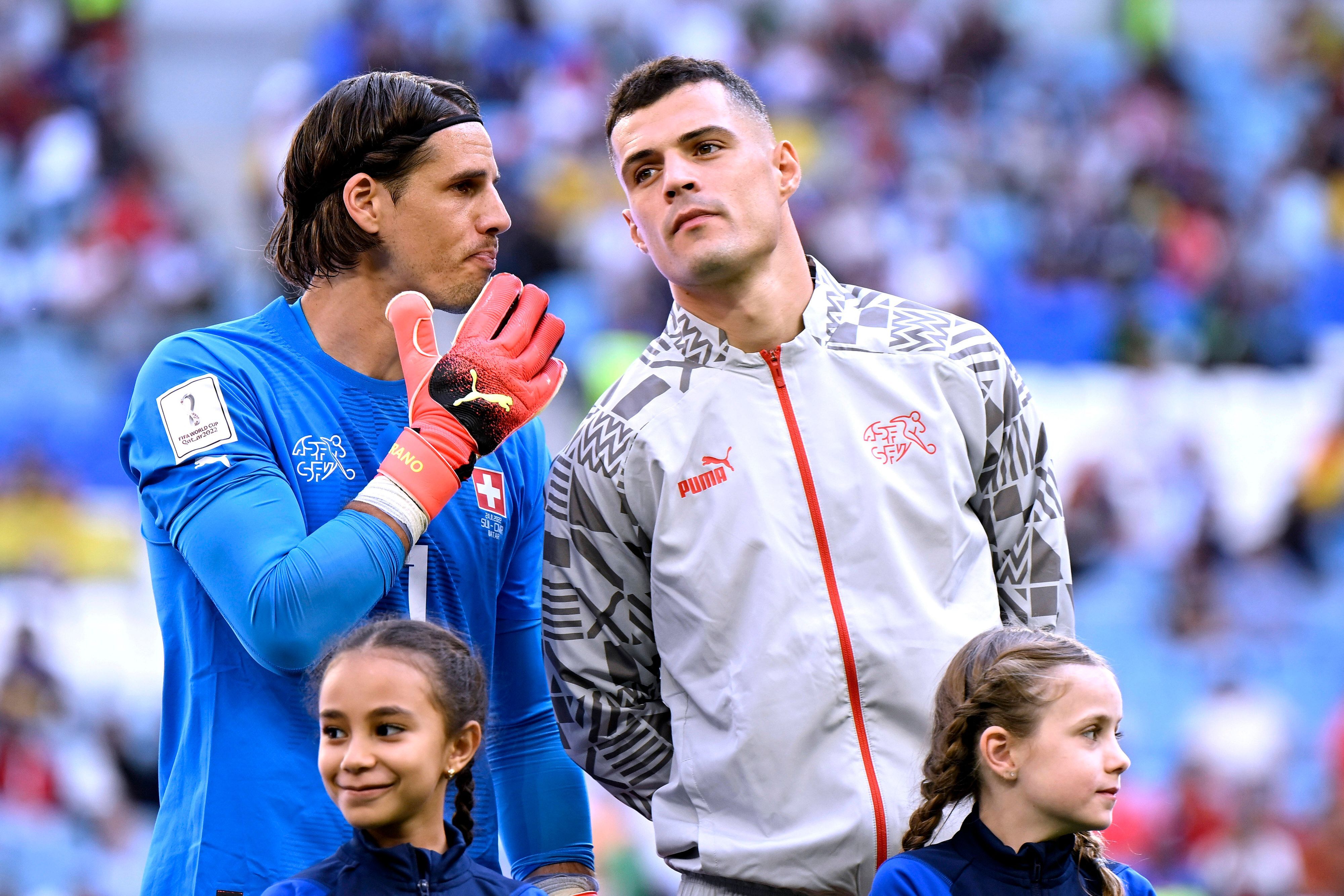 Granit Xhaka (r.) steht vor dem WM-Spiel der Schweiz gegen Kamerun am 24. November 2022 bei der Nationalhymne neben Torhüter Yann Sommer, die beiden ehemaligen Spieler von Borussia Mönchengladbach sprechen miteinander.