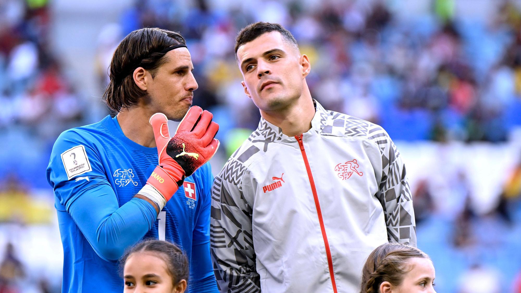 Granit Xhaka (r.) steht vor dem WM-Spiel der Schweiz gegen Kamerun am 24. November 2022 bei der Nationalhymne neben Torhüter Yann Sommer, die beiden ehemaligen Spieler von Borussia Mönchengladbach sprechen miteinander.