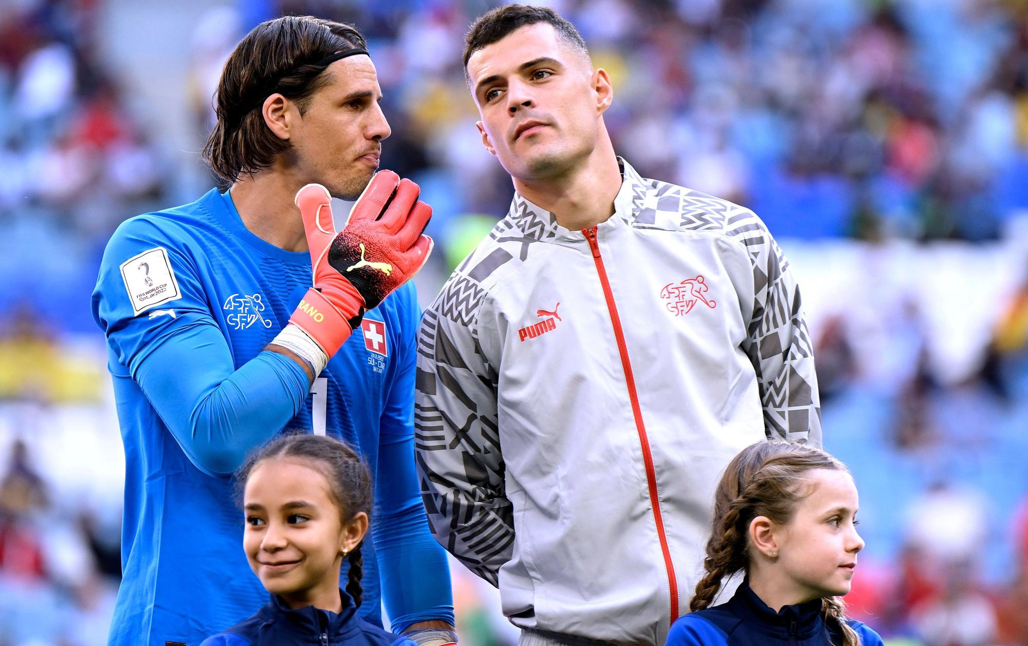 Granit Xhaka (r.) steht vor dem WM-Spiel der Schweiz gegen Kamerun am 24. November 2022 bei der Nationalhymne neben Torhüter Yann Sommer, die beiden ehemaligen Spieler von Borussia Mönchengladbach sprechen miteinander.