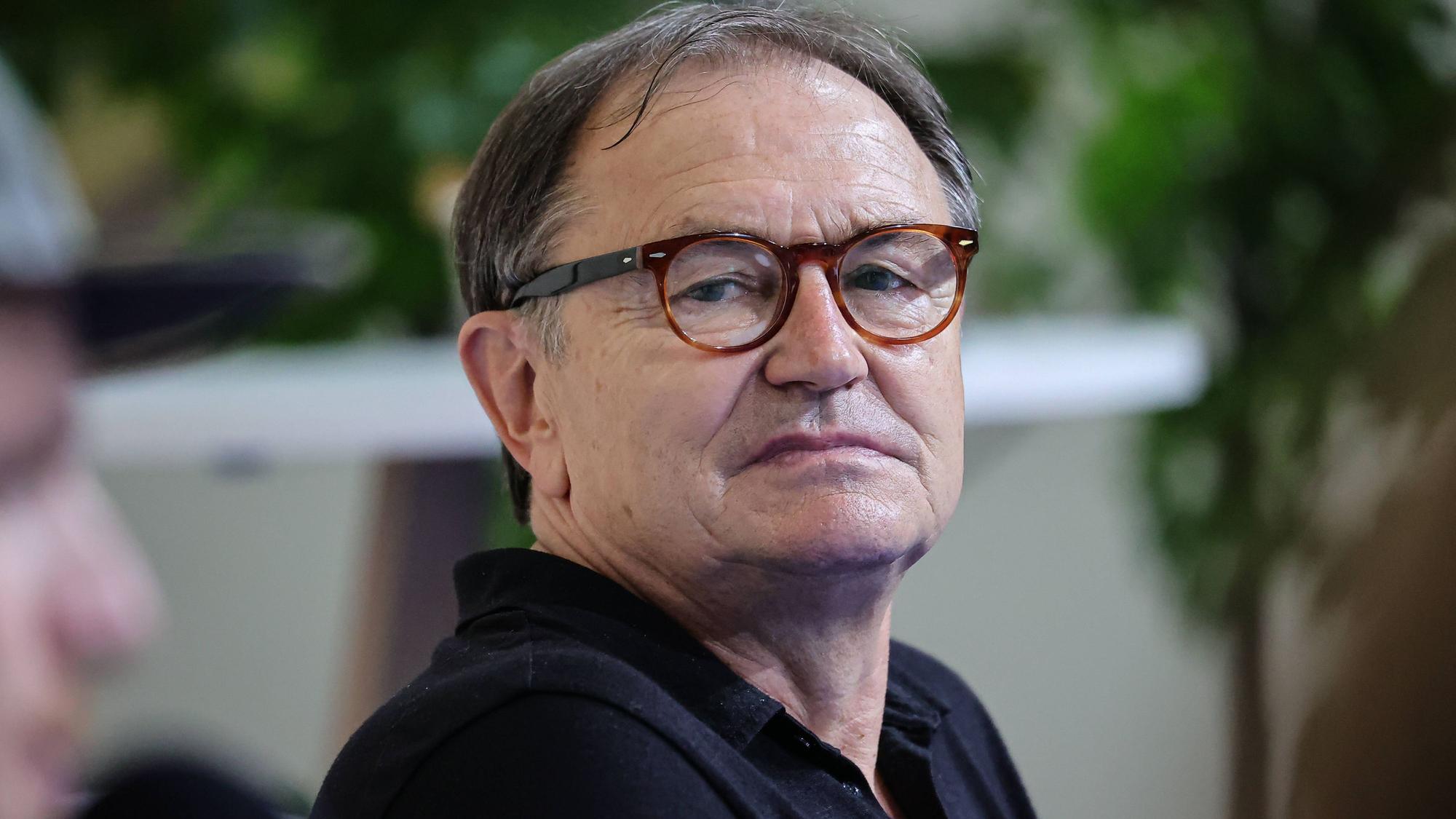Ewald Lienen, ehemaliger Trainer von Borussia Mönchengladbach und dem FC St. Pauli, nimmt am 28. August 2021 an einer Podiumsdiskussion in Düsseldorf teil. Lienen trägt ein schwarzes Polo-Shirt.