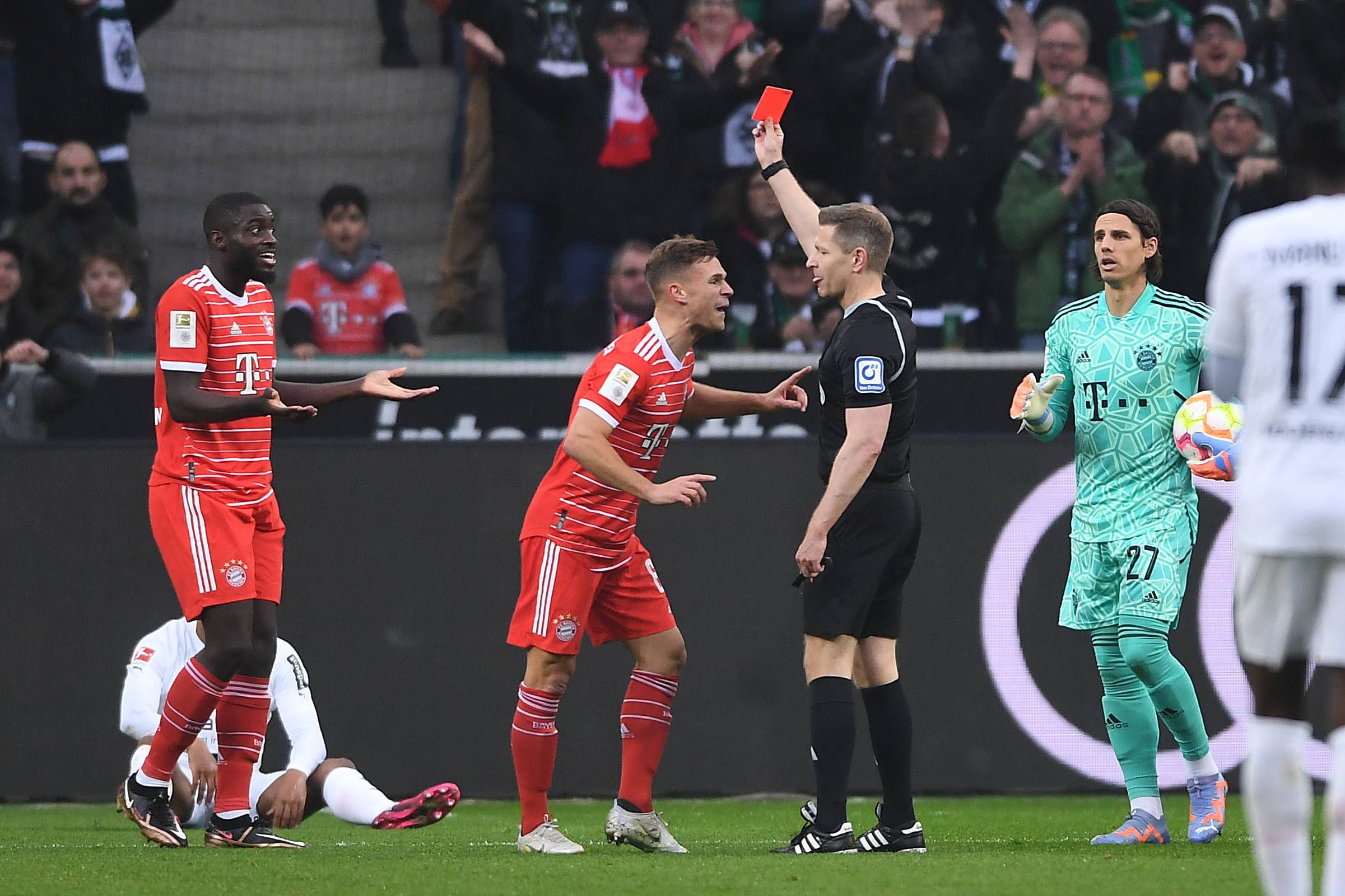 Schiedsrichter Tobias Welz zeigt Dayot Upamecano (l.) von Bayern München die Rote Karte. Joshua Kimmich (2.v.l.) redet derweil auf den Unparteiischen wütend ein.